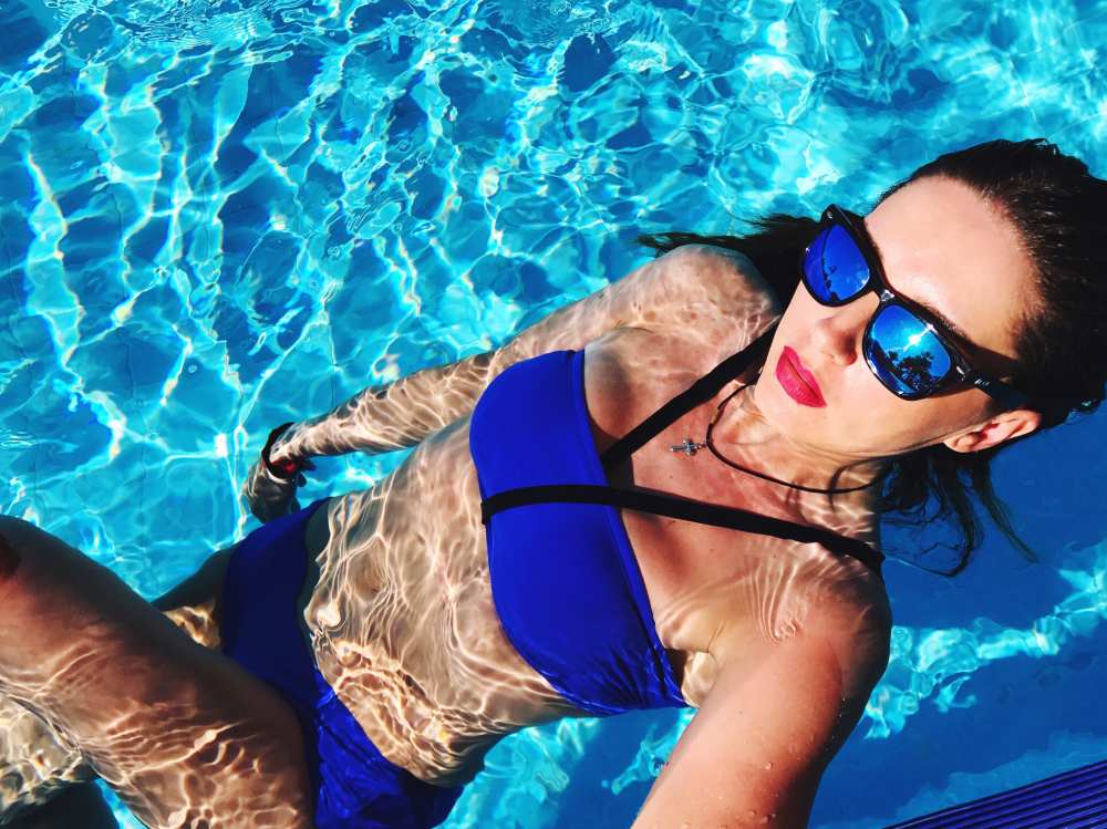 Woman in pool with bright lipstick and bikini