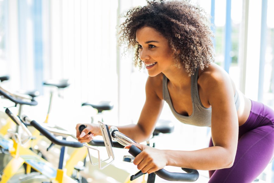 Woman Doing Cardio Exercises on a Stationary Bike at the Gym