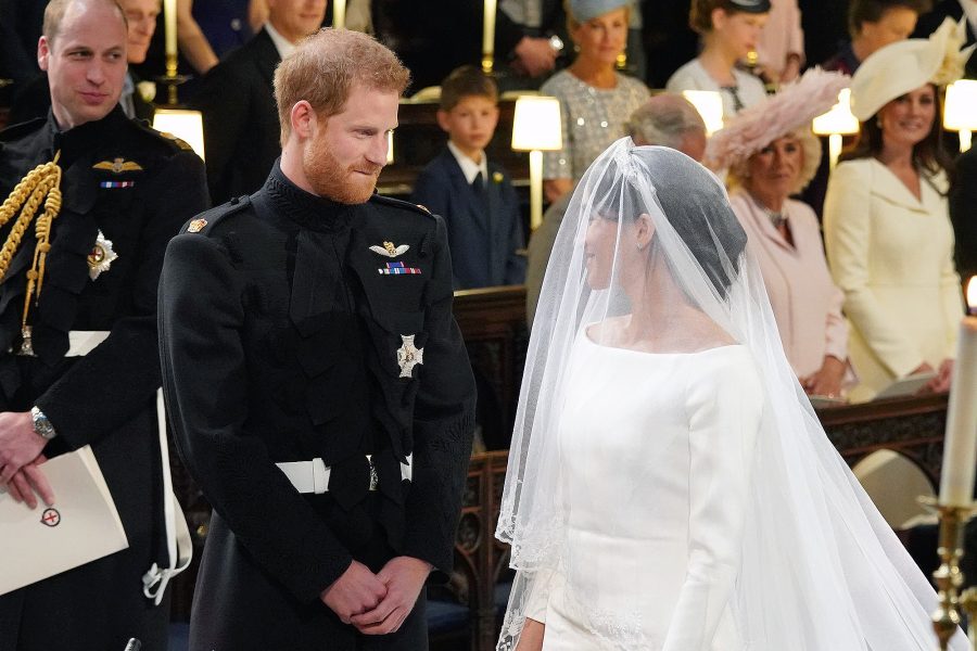 Prince Harry bites his lip while gazing at Meghan Markle.