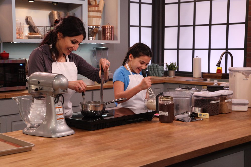 Mary and Isabella mix batter at their stovetop.