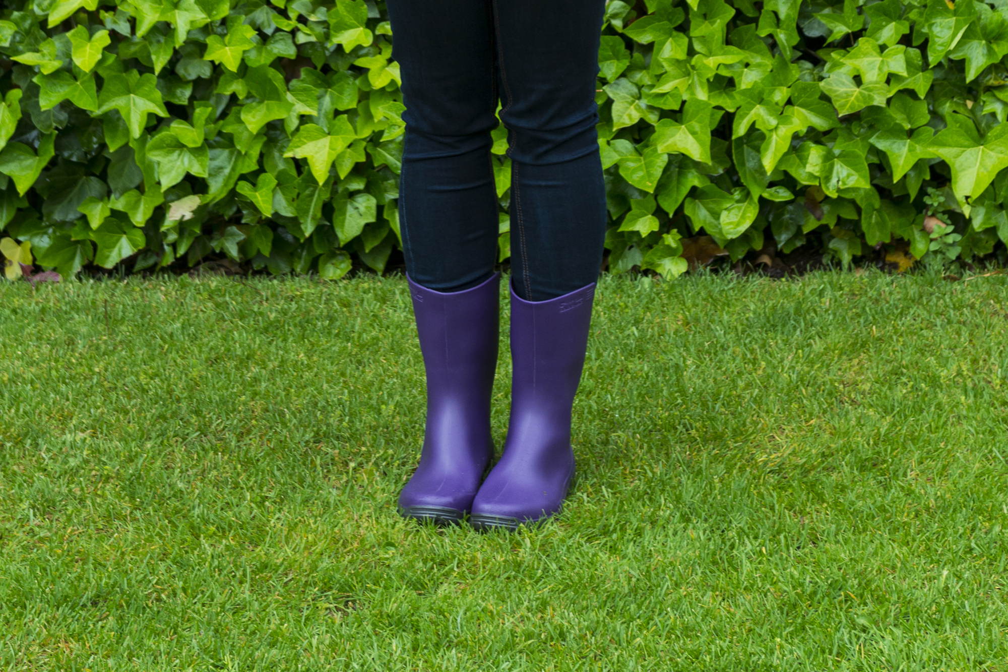 Young woman with playing with a colorful umbrella in a rainy day.