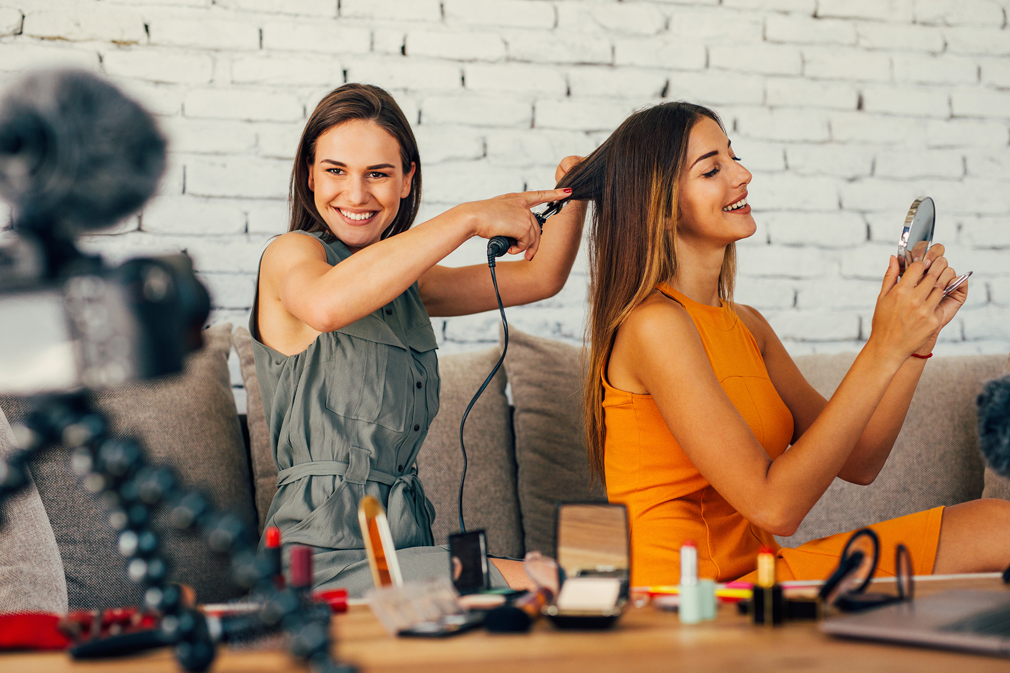 Two women doing a hairdo vlog at home.