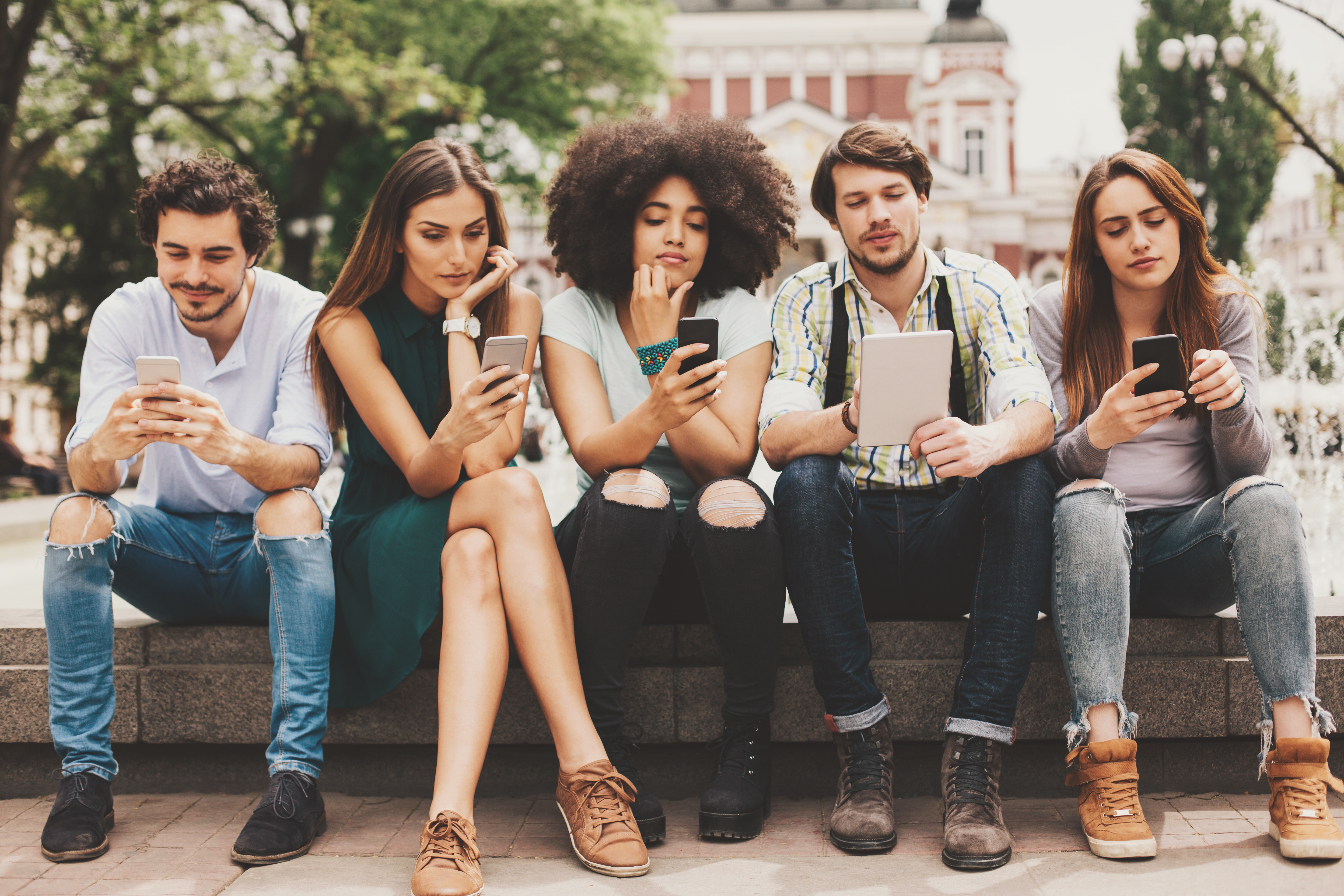 Group of mixed race people looking at mobile phones