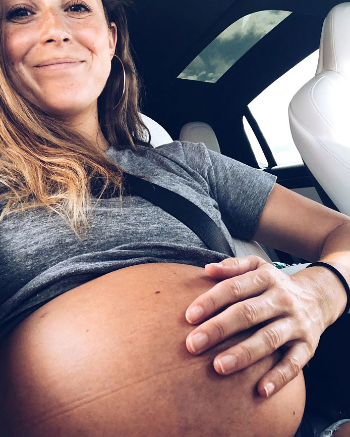 Alexa PenaVega Holds Her Pregnant Belly While Smiling