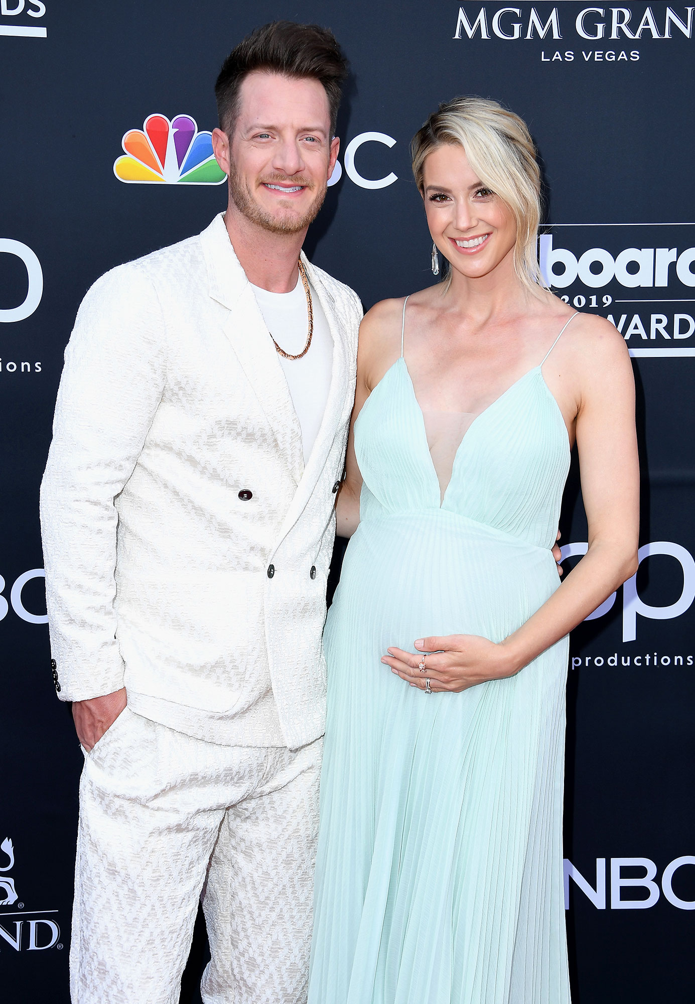 Tyler Hubbard Wearing A White Suit and Hayley Stommel Hubbard Pregnant Wearing A Blue Dress