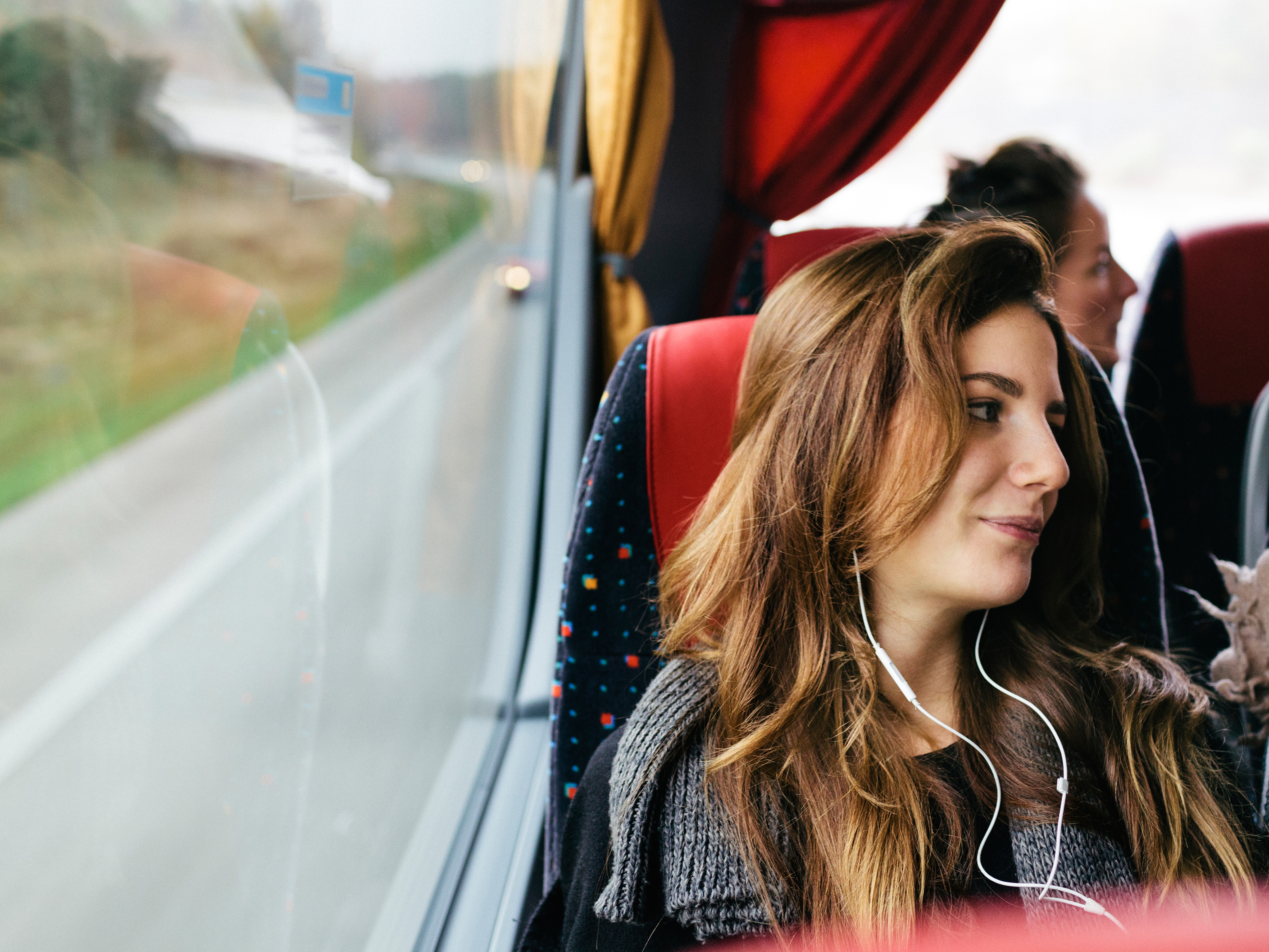 A young woman travelling with bus while listening music