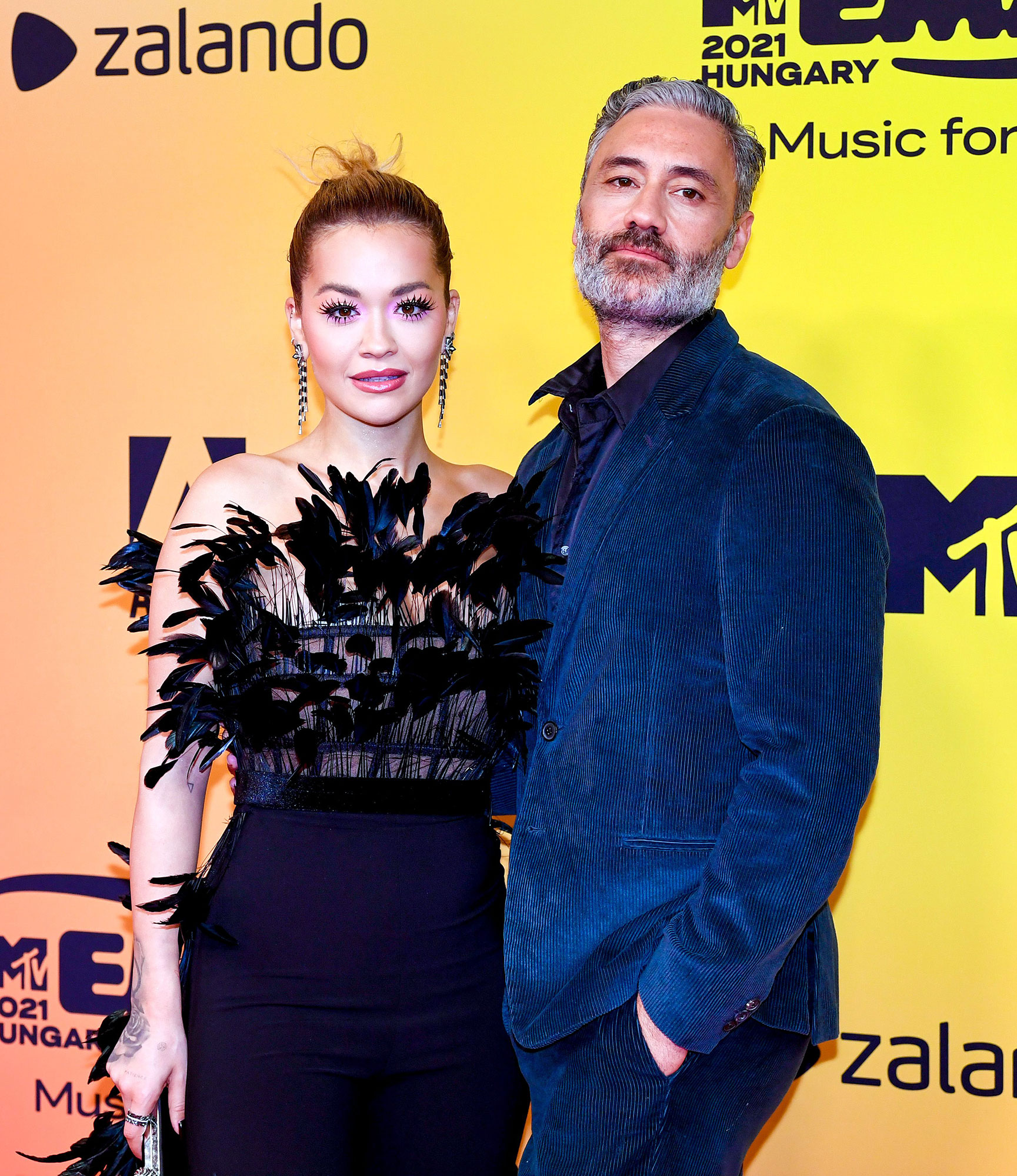 To the Rescue Taika Waititi Fixes Girlfriend Rita Ora’s Dress on 2021 EMAs Red Carpet