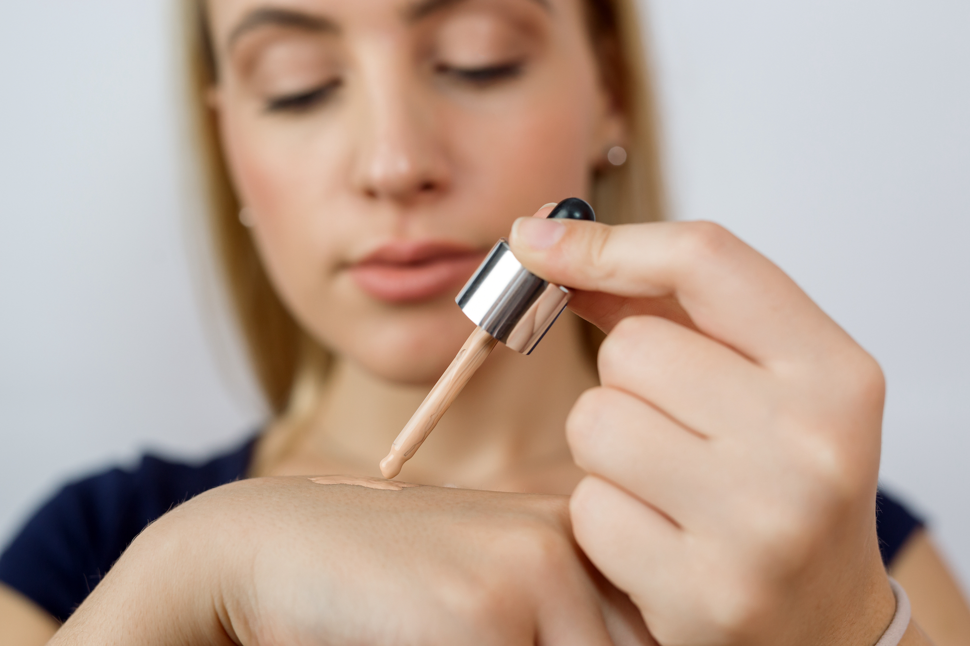 Woman-Putting-On-Liquid-Foundation-Stock-Photo