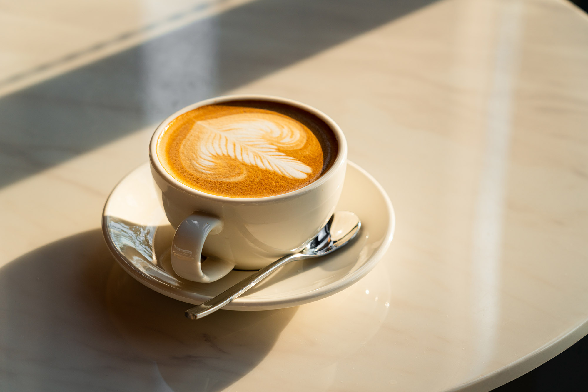 Feshly brewed latte coffee on a white table, a coffee drink made with espresso and steamed milk.