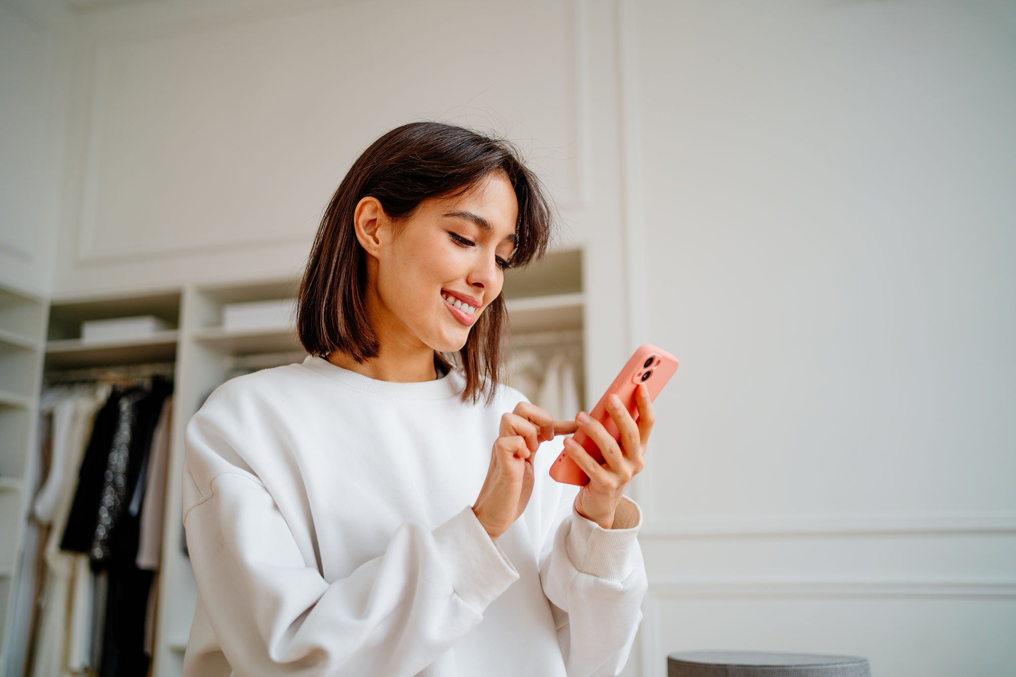 Saleswoman making orders using phone, working in design department of clothes store