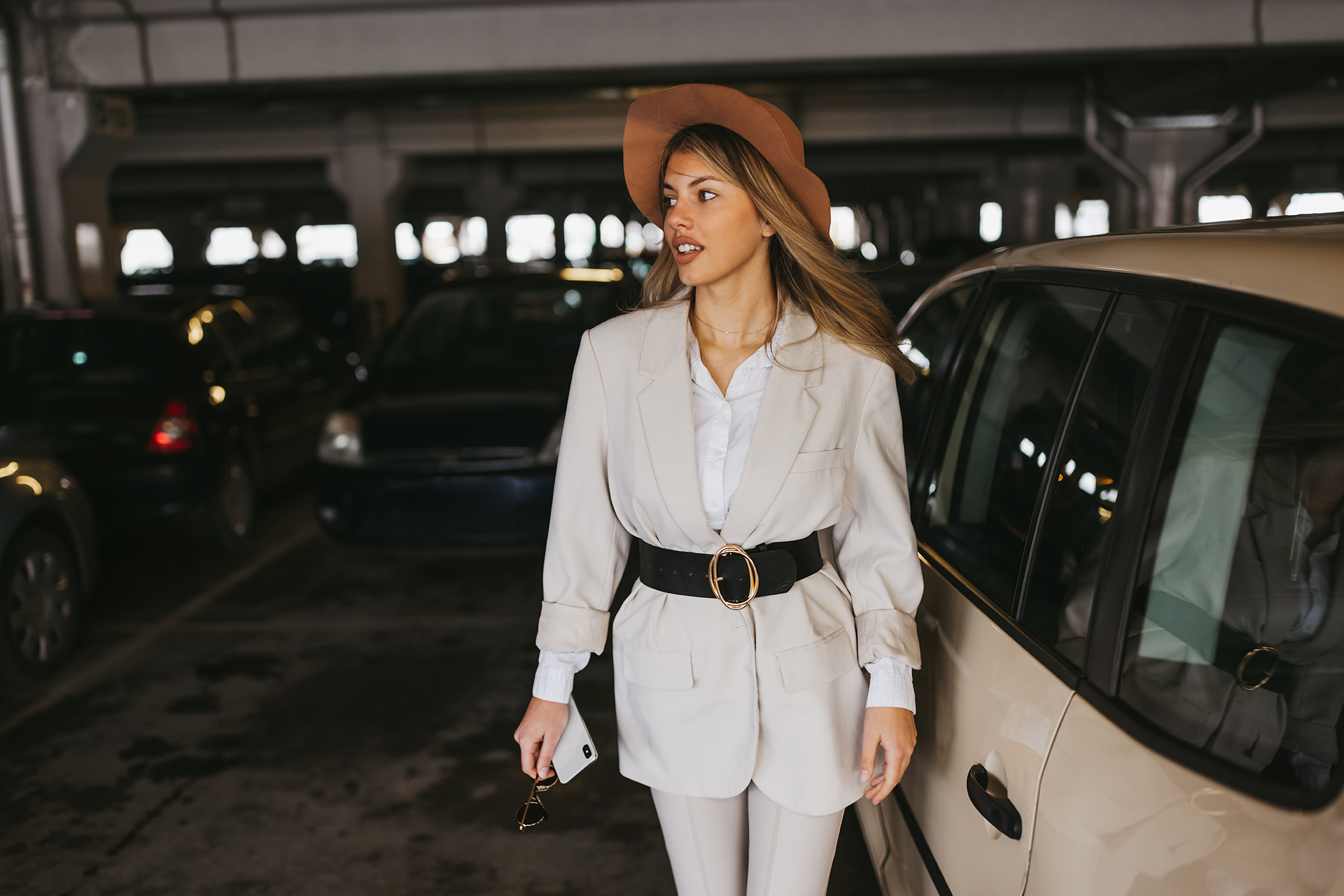 Elegant young woman walking on shopping mall parking lot
