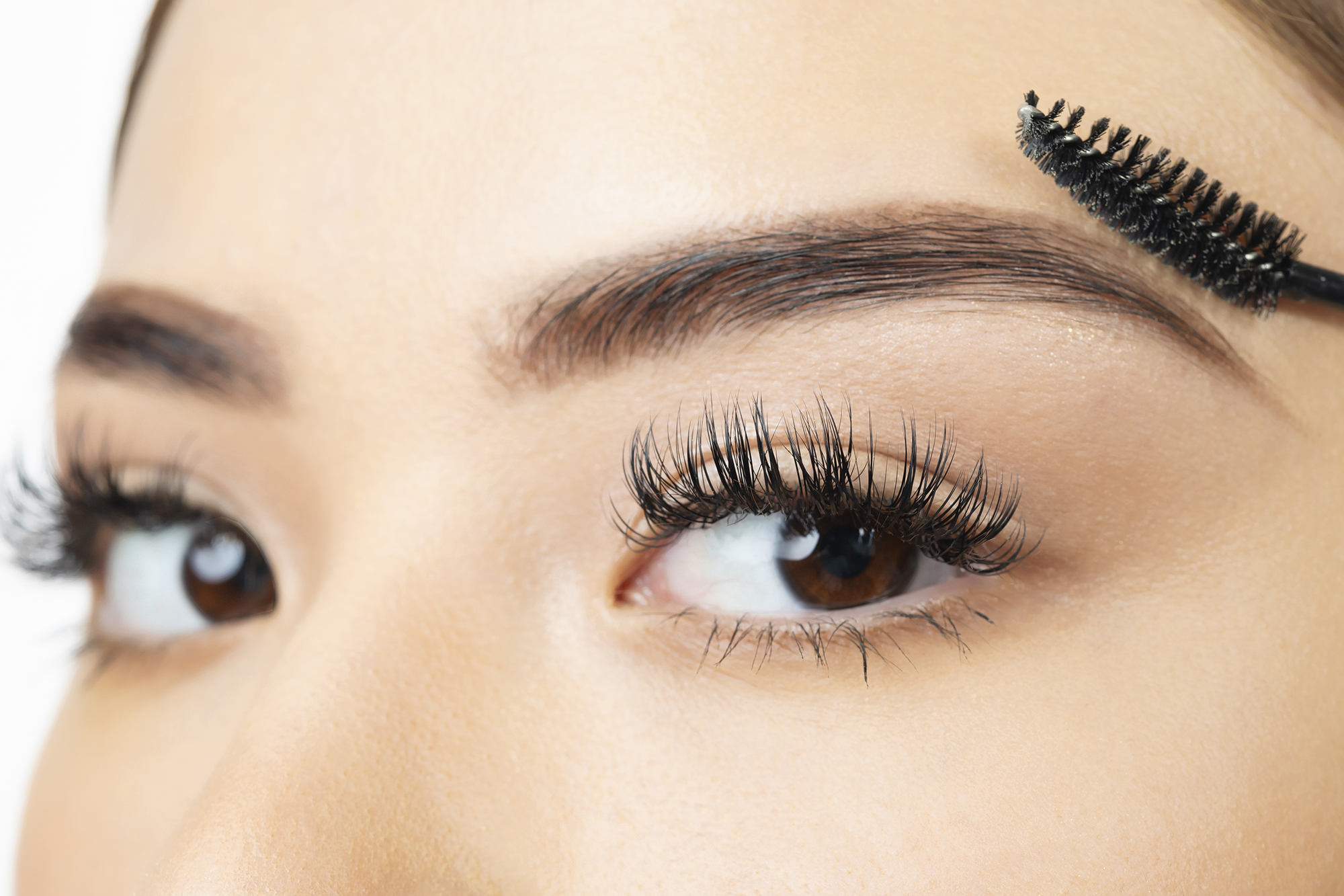 Young woman looking at the camera in the last step of brushing her eyebrow