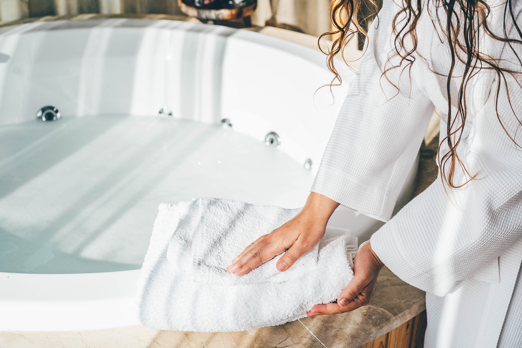 Woman holding white bath towels.