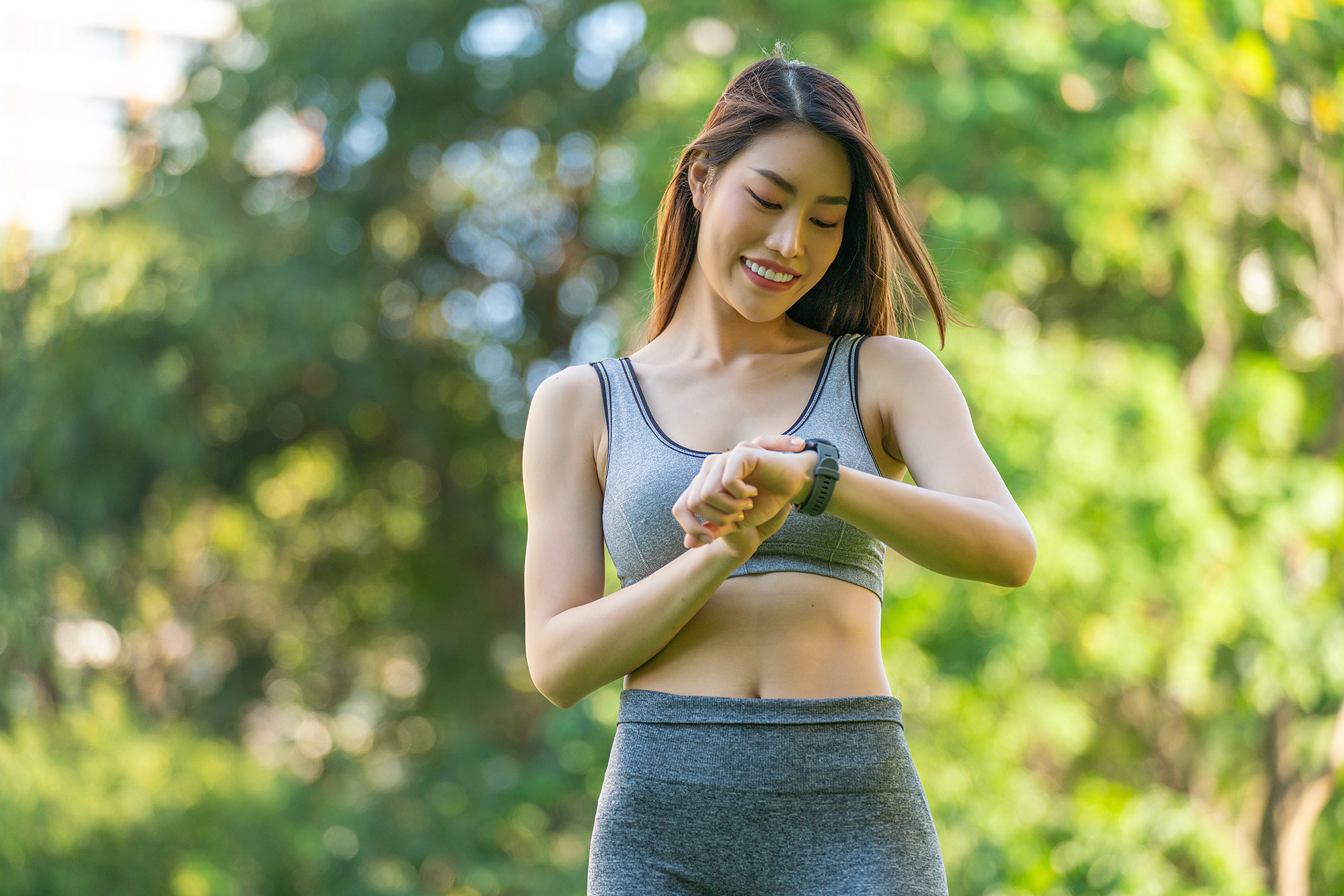 Portrait of a Young Woman in Sportswear and Smartwatch Enjoying Healthy Living and Exercise, Radiating Happiness and Positivity During Leisure Exercise in a Public Park at Sunset. Positive Vibes. Enjoying Healthy Living And Outdoor Wellbeing. Smart Wellness.
