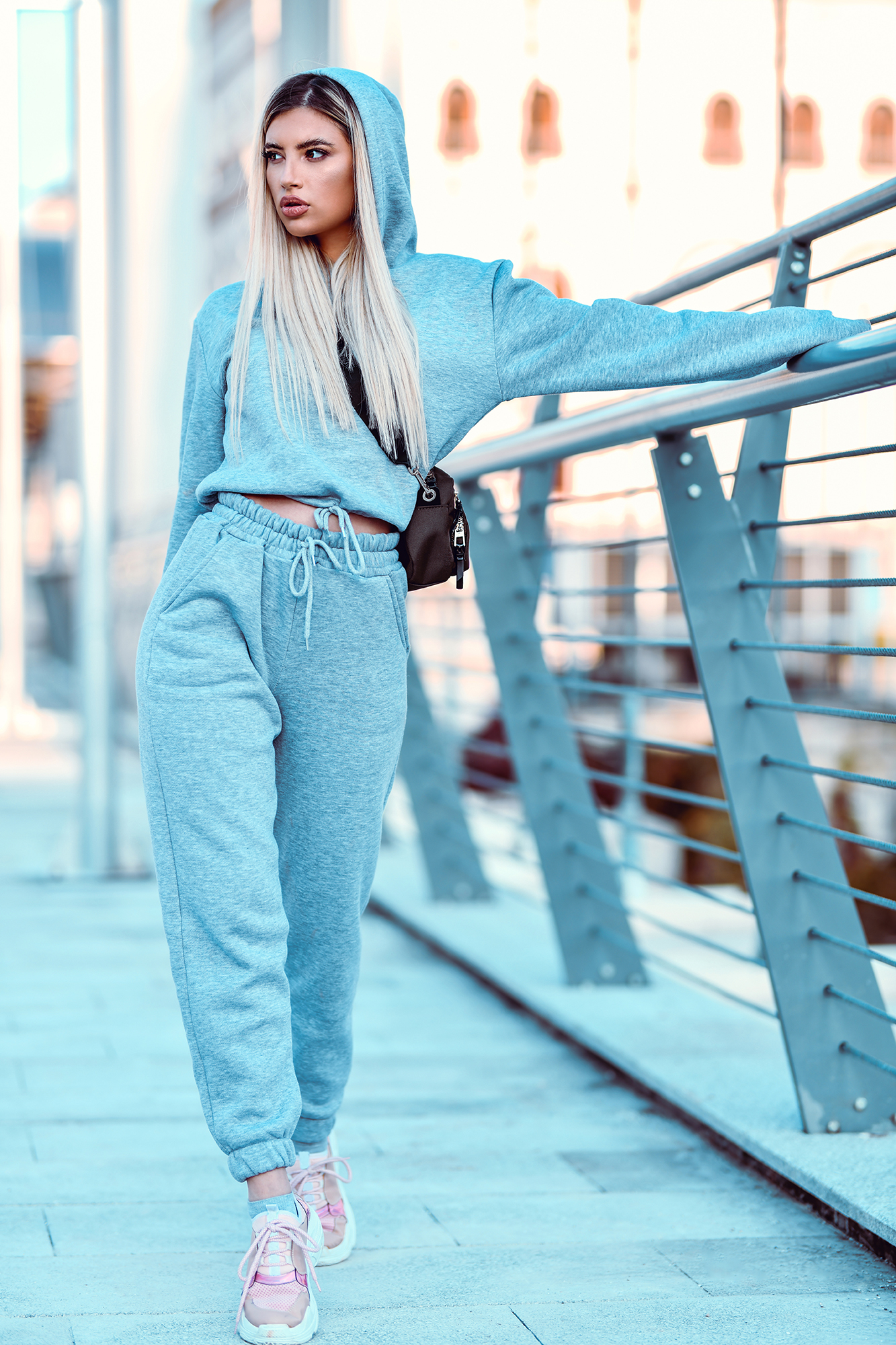 Beautiful Female In Tracksuit Walking On Bridge And Holding Railing