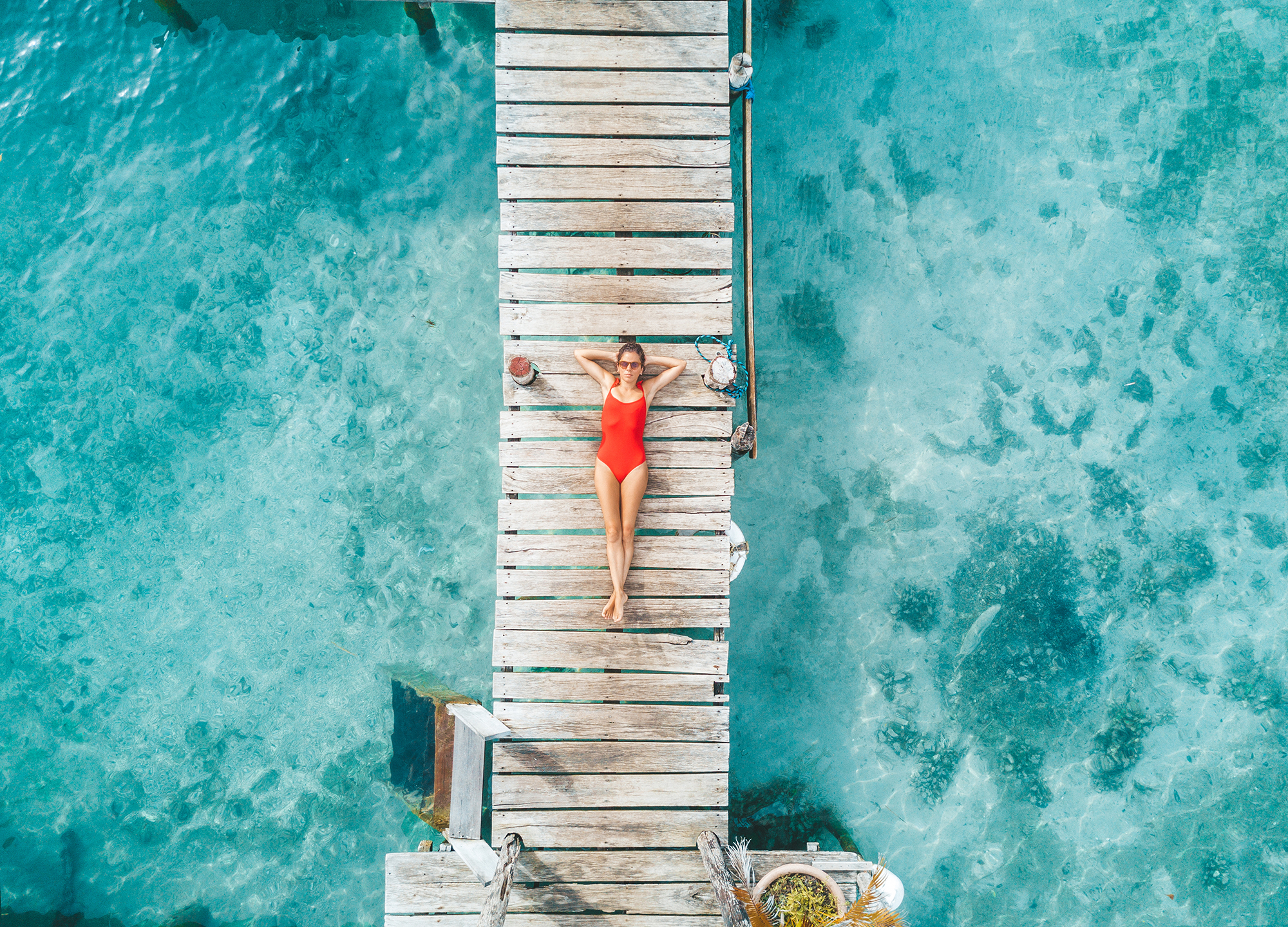 Aerial shot of woman relaxing in a water bungalow