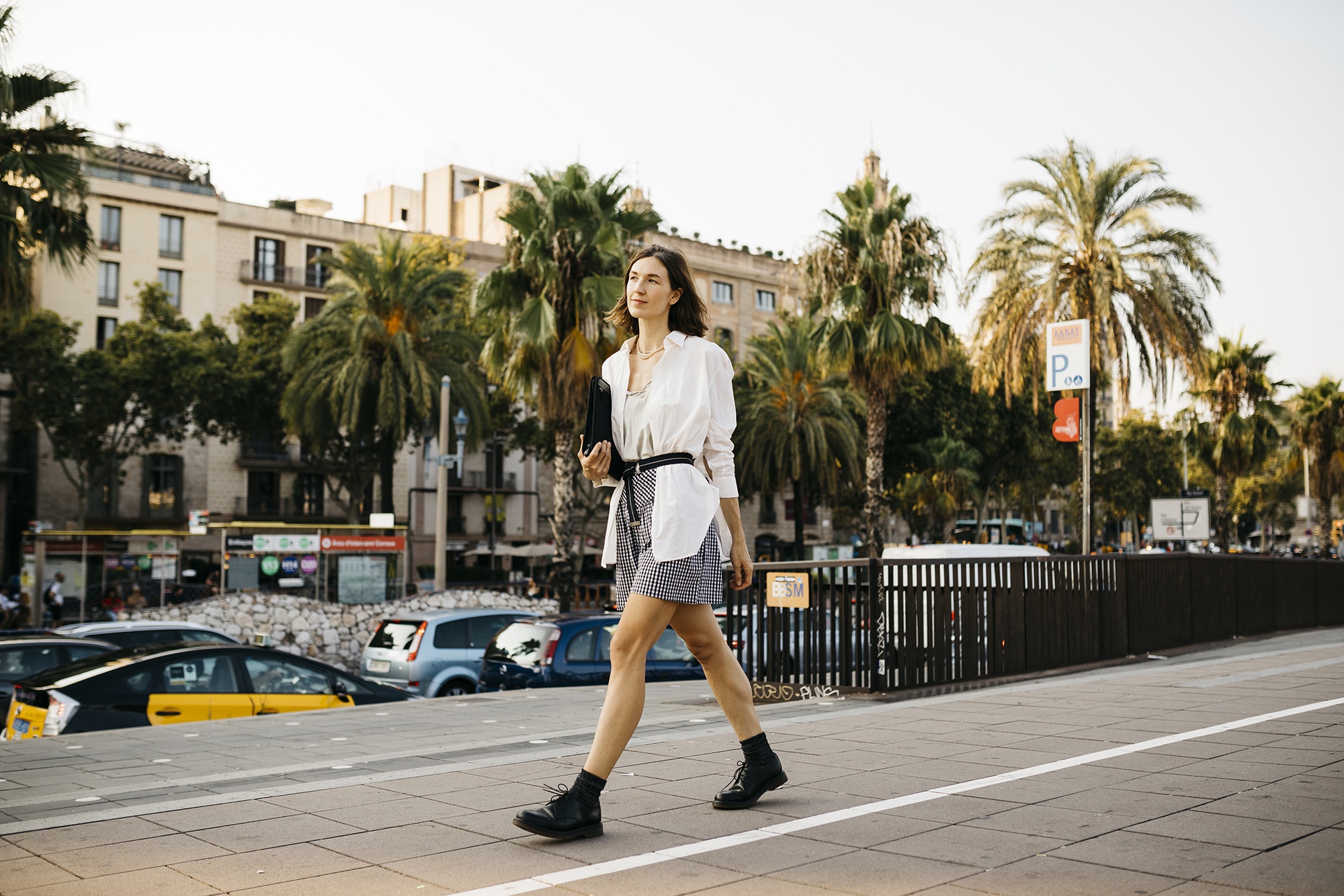 Pretty businesswoman carrying folder, walking in the city