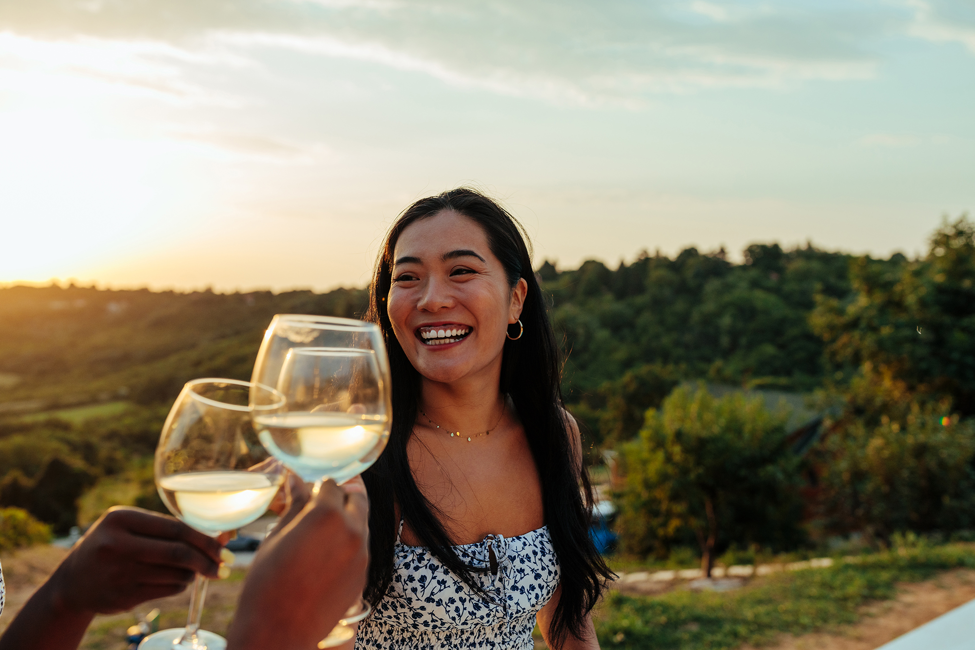 Happy woman having fun while toasting with wine at vineyard party