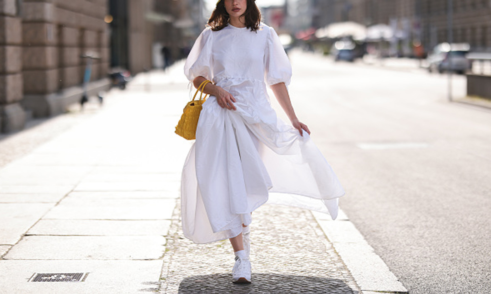 Woman wearing white dress and sneakers