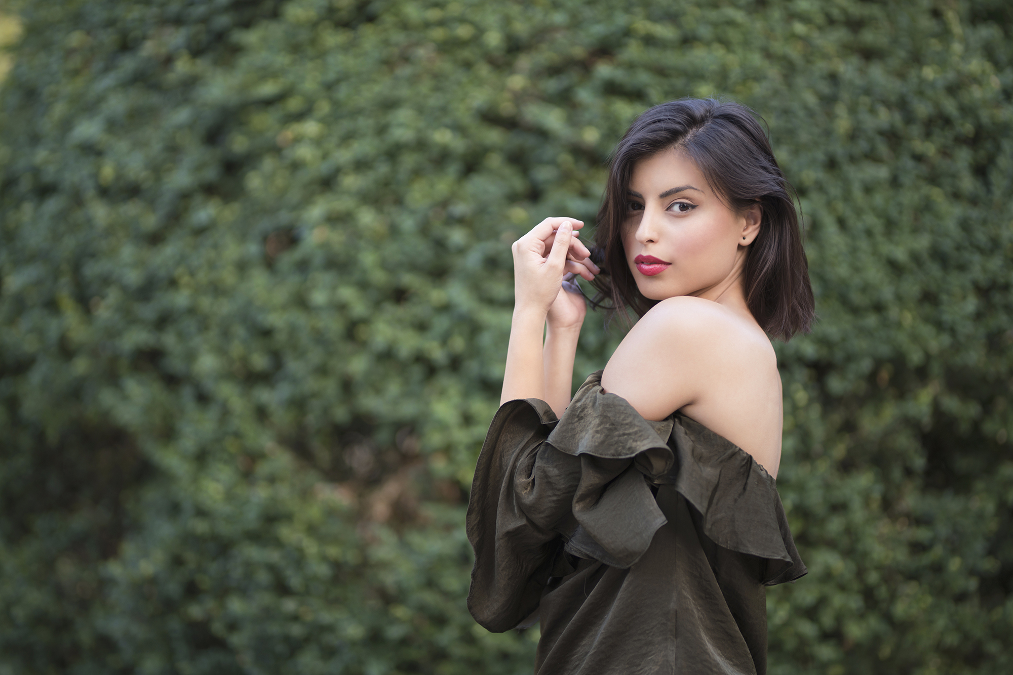 Fashion portrait of a beautiful, young woman wearing off - shoulder shirt.