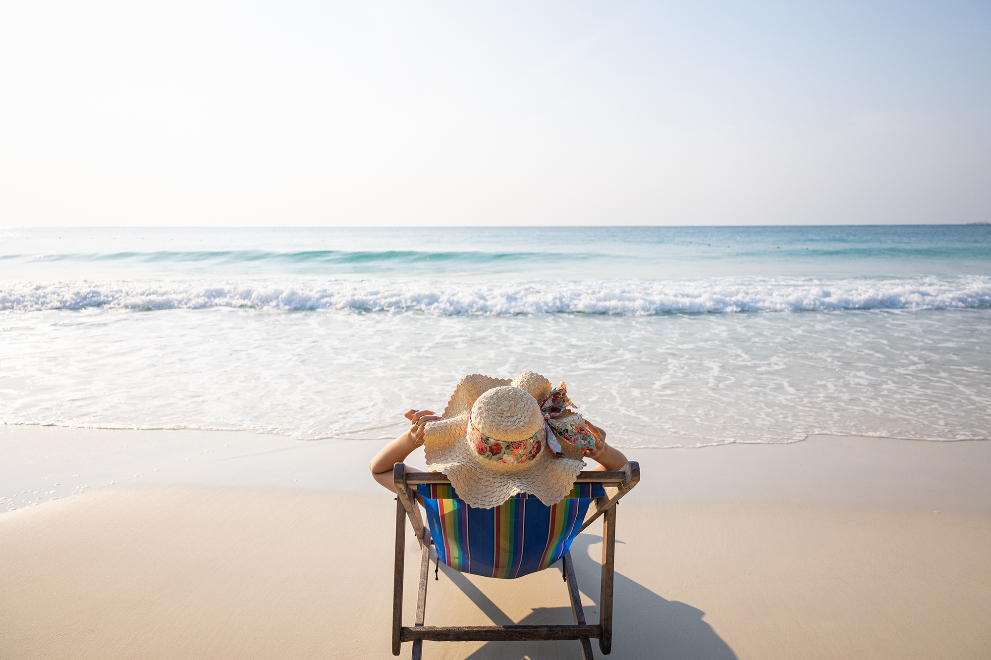 Woman relaxing in lawn chair on beach