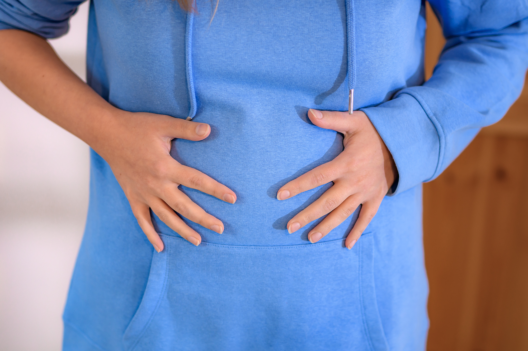 woman having abdominal bloating, overeating, round tummy close up macro