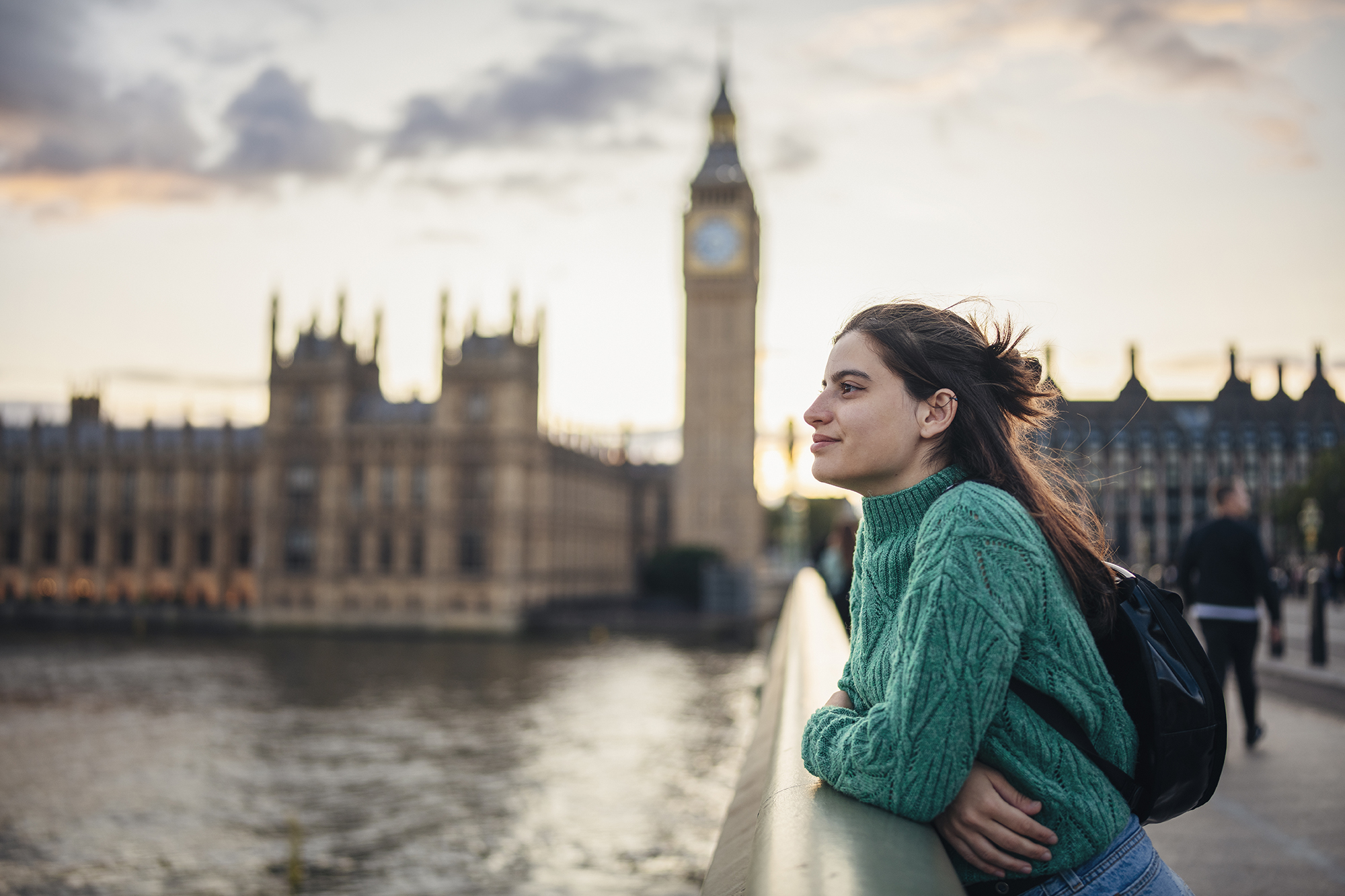 Young female tourist admiring the beauty of city of London on the Westminster bridge next to Big Ben.