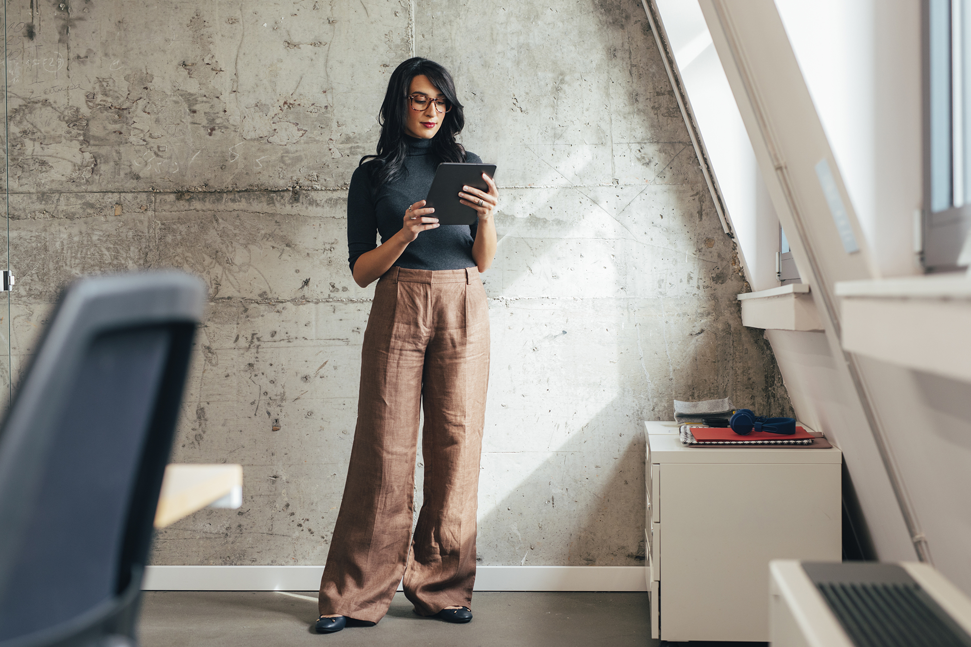 A businesswoman reading something on a tablet pc in her hands.