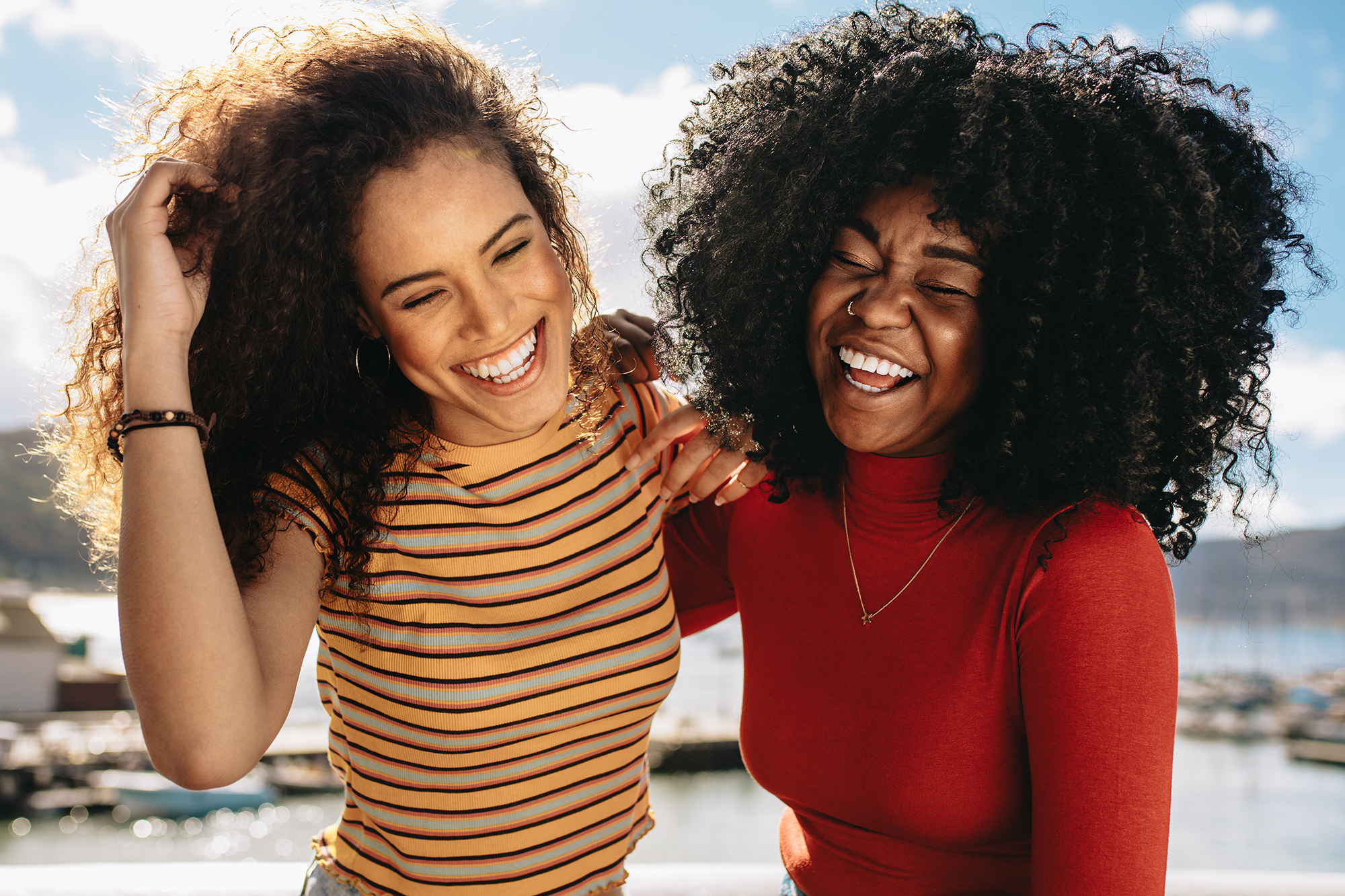 Cheerful young women enjoying a day out on the beach. Female friends having fun on the sea shore.