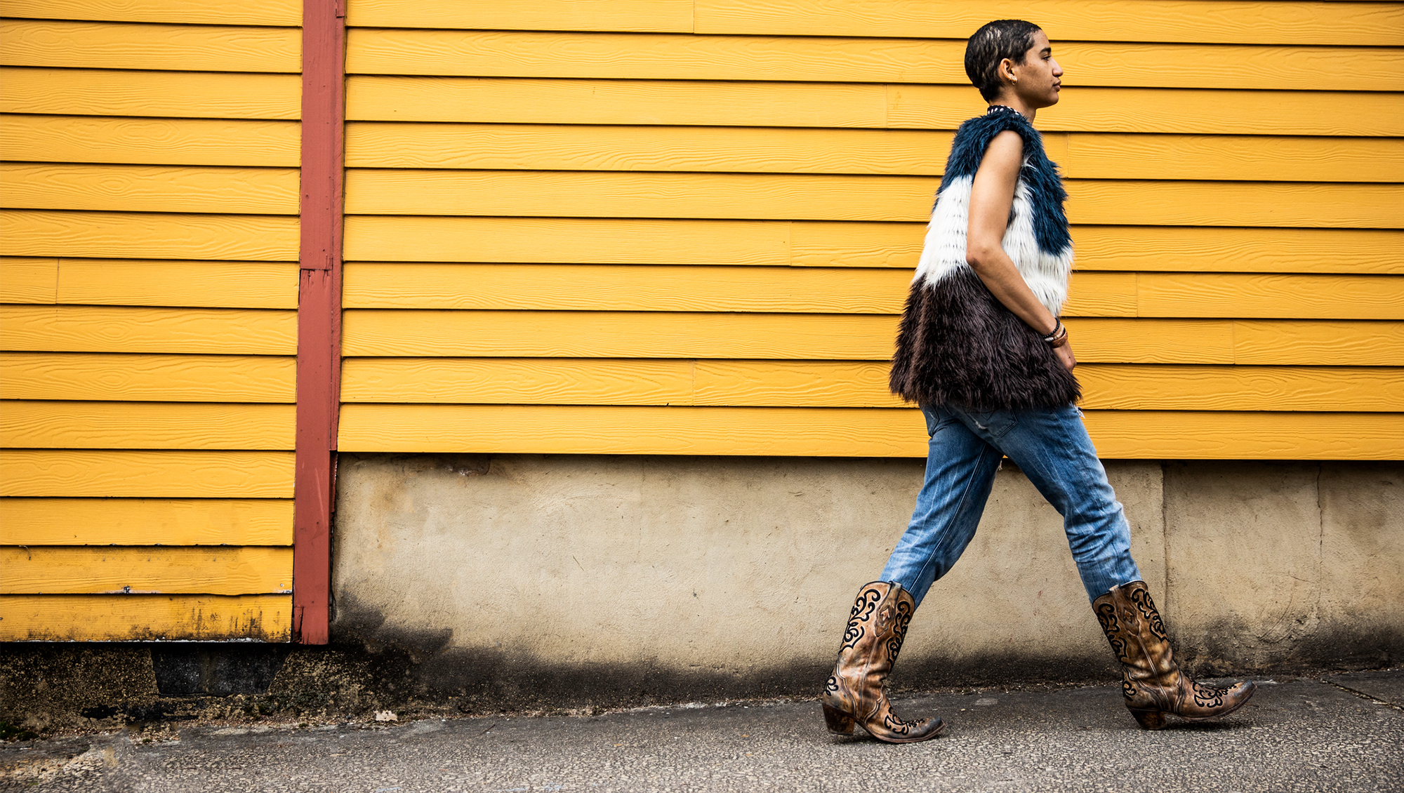 woman in cowboy boots walking on a street