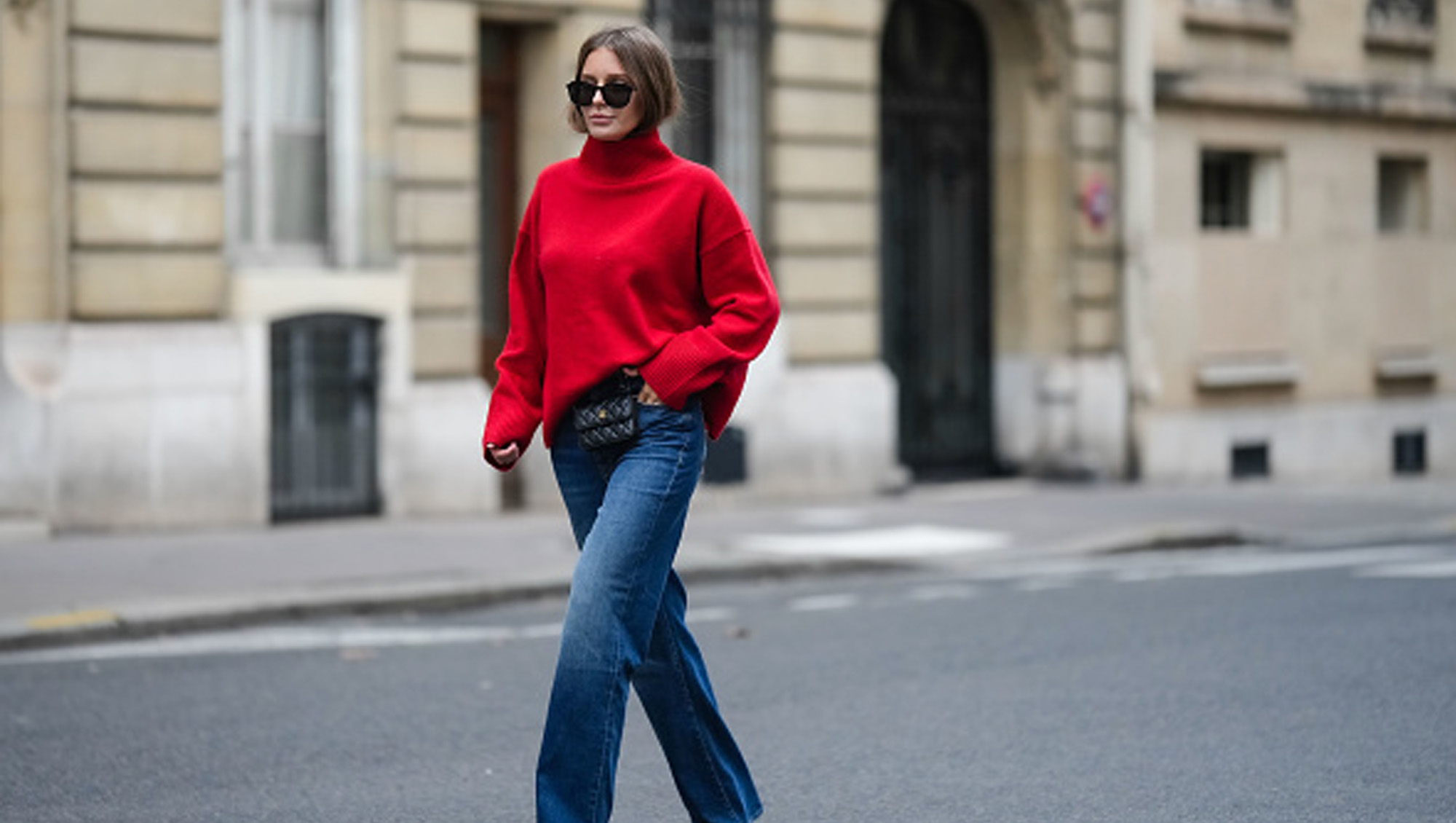 woman wearing loose red sweater and blue jeans