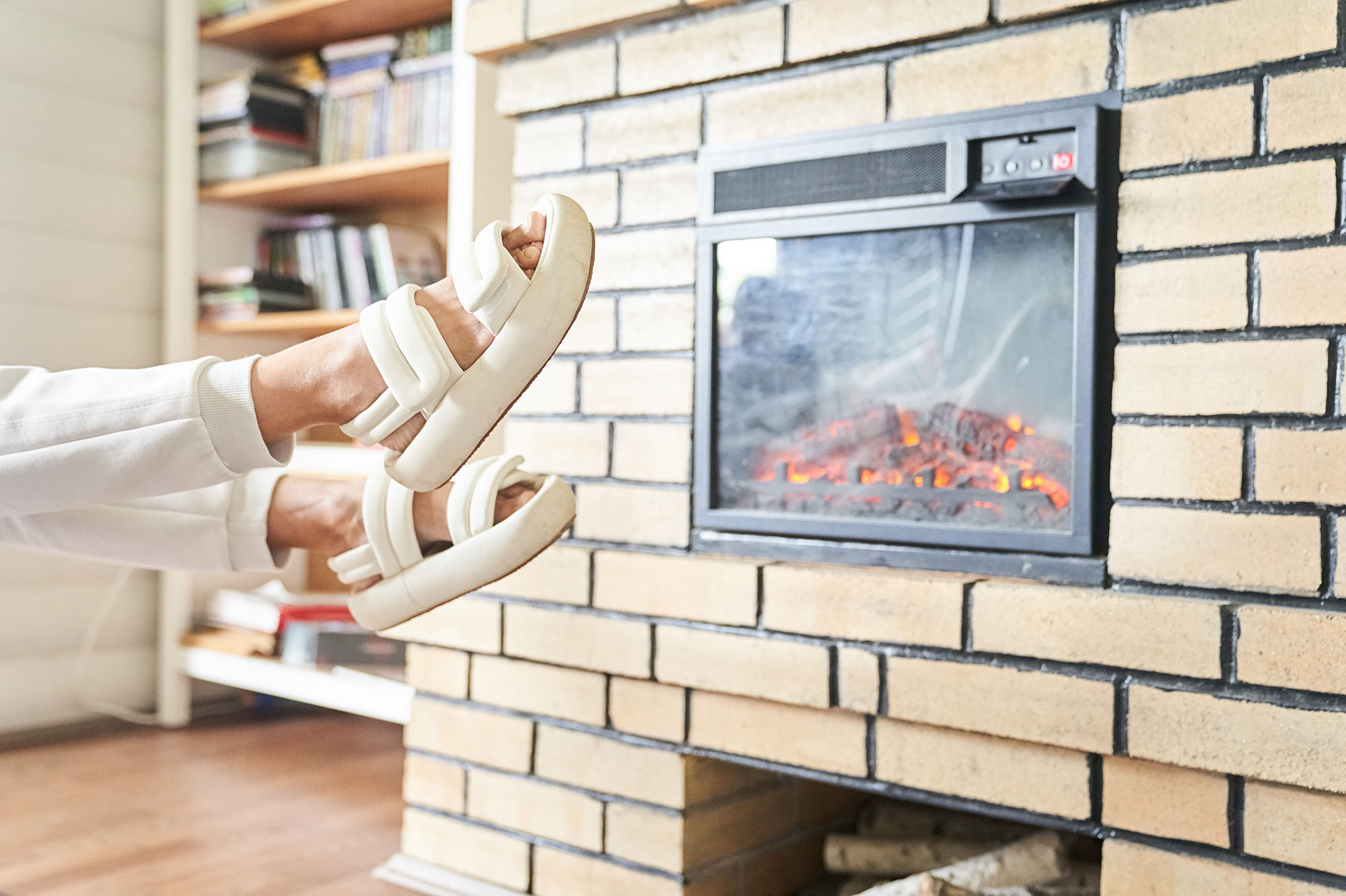 woman wearing slippers in front of fireplace