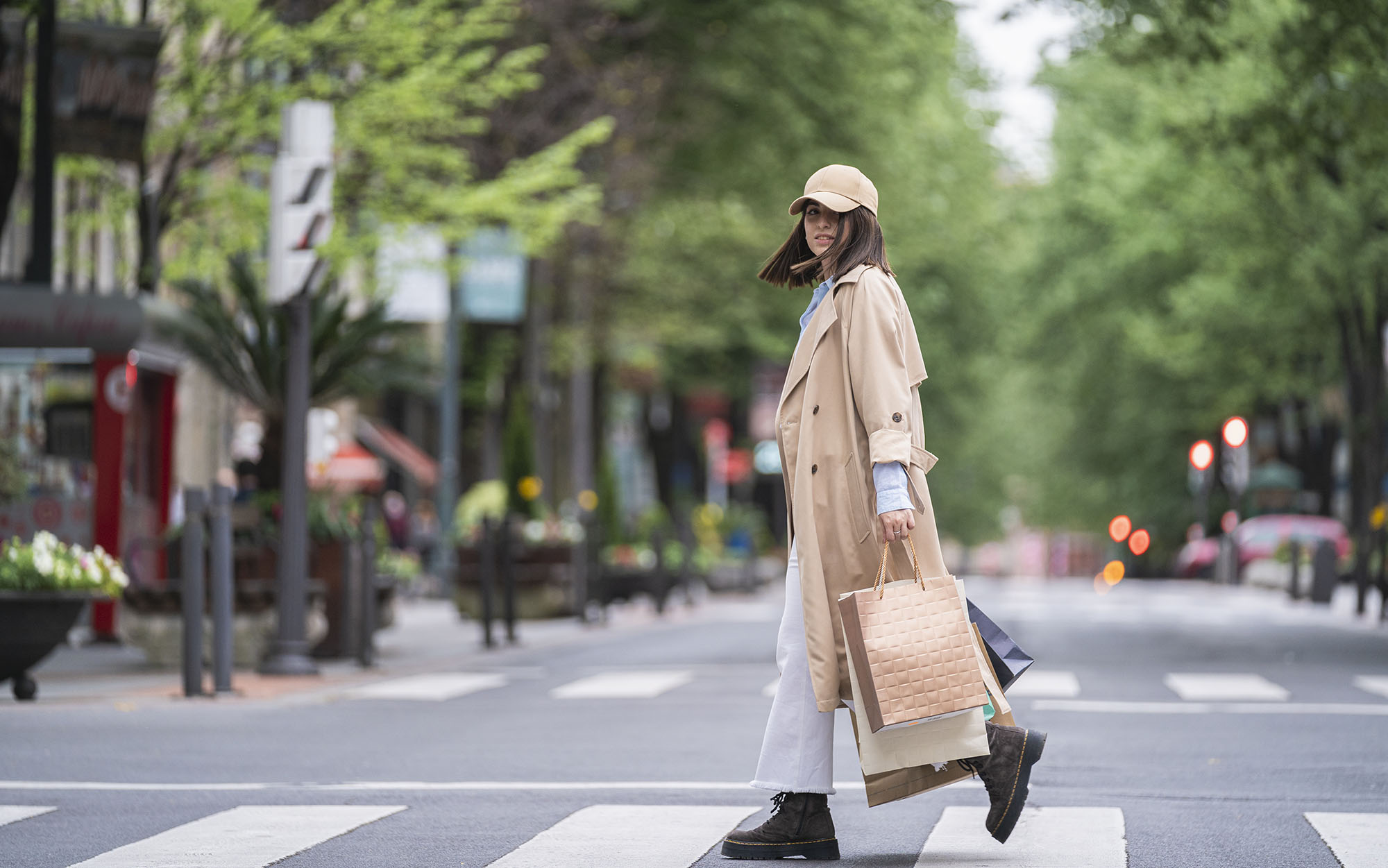 Young woman with shopping bags walking on road