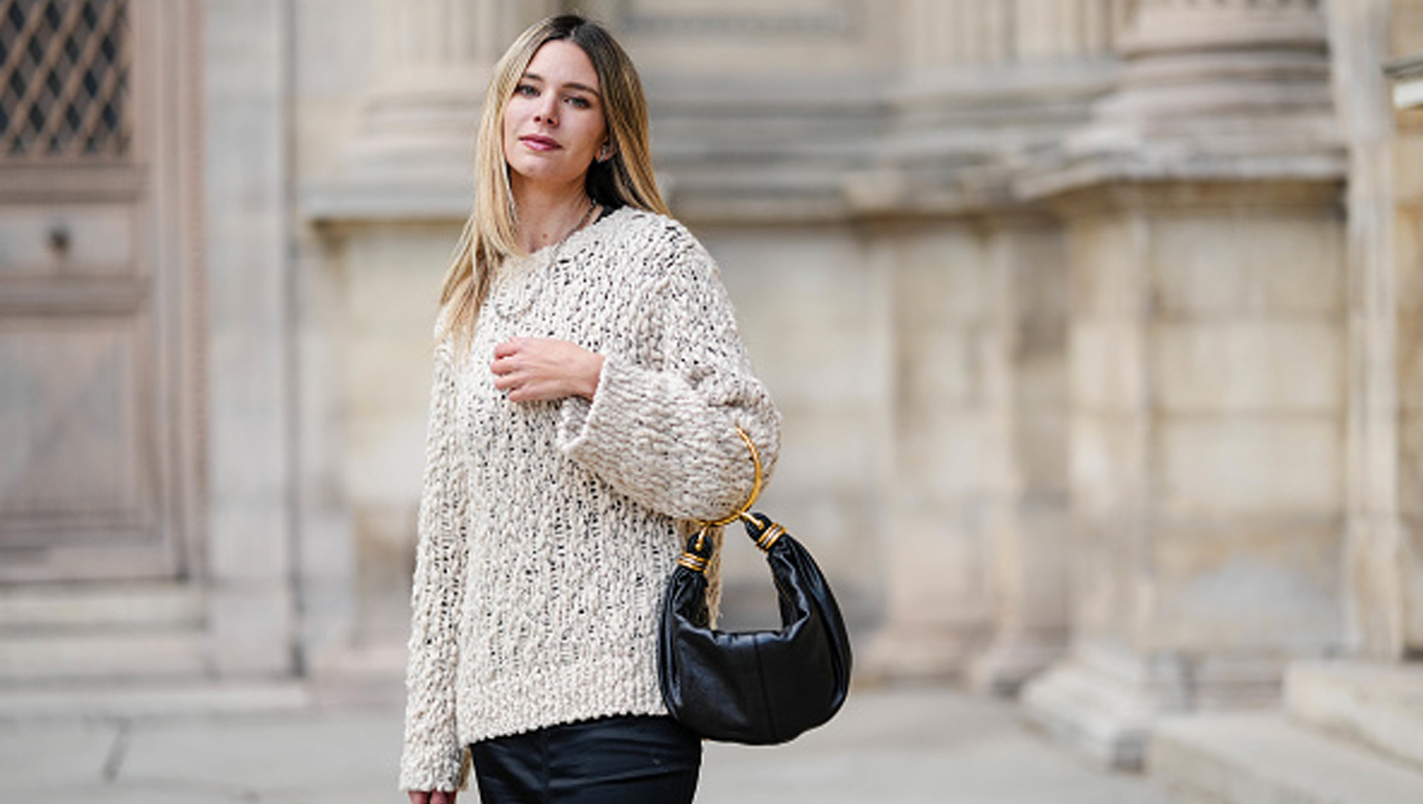 woman wearing fuzzy sweater and black bag