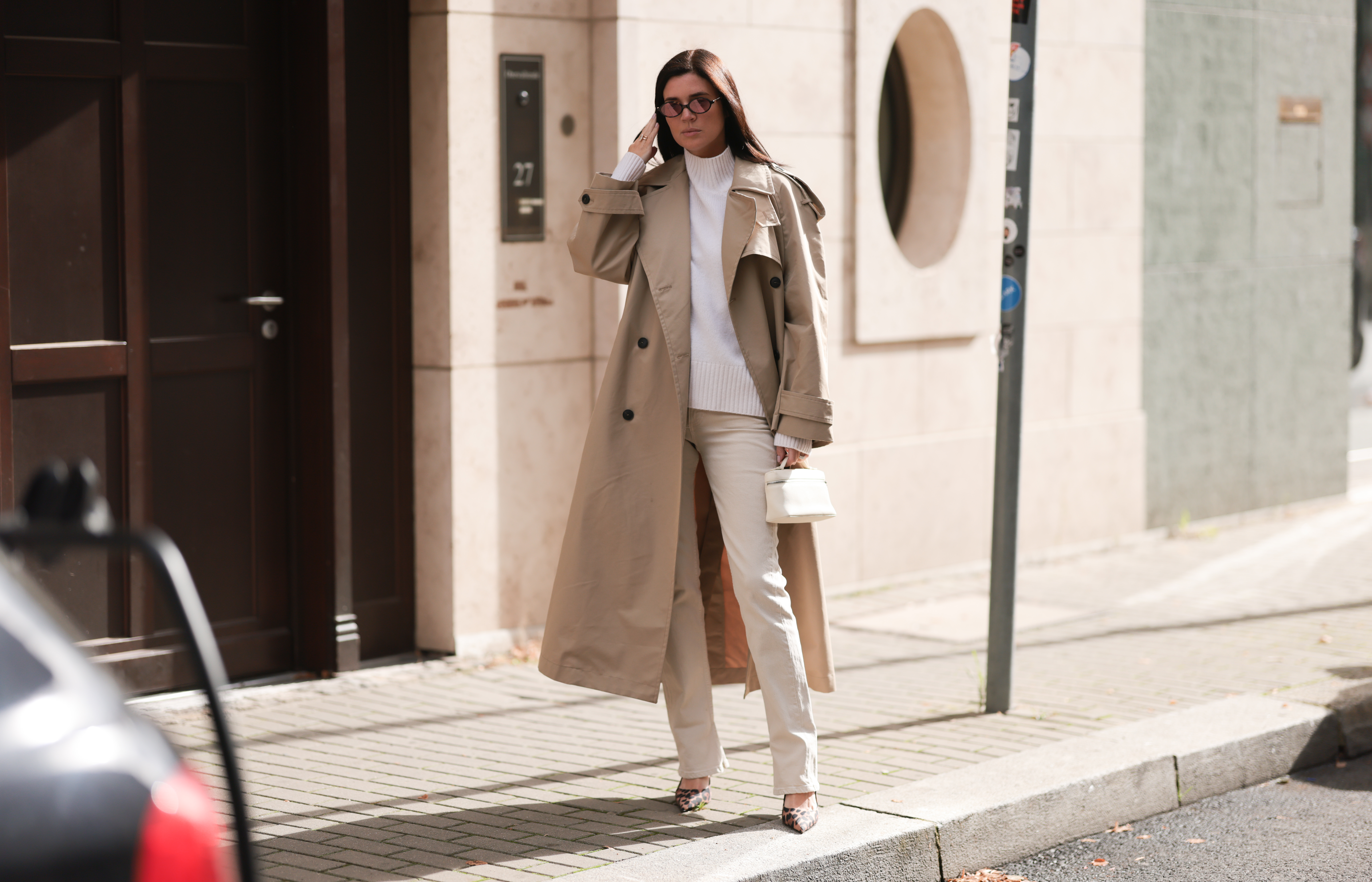 woman wearing beige coat, white sweater and cream pants