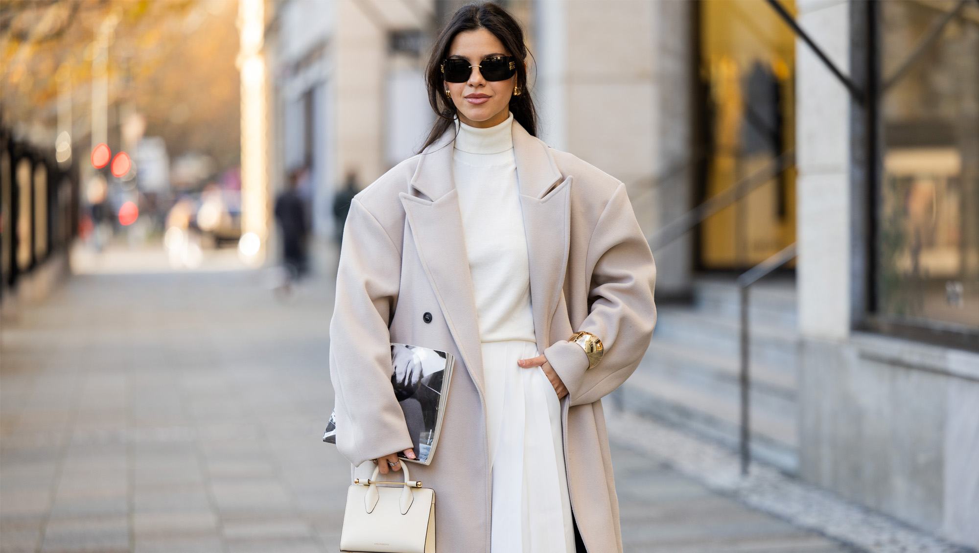 Bella Emar wears oversized grey double breasted sourceunknown coat, creme white turtleneck top Zara, white wide leg pants Frankie Shop, strathberry bag on November 30, 2024 in Berlin, Germany.