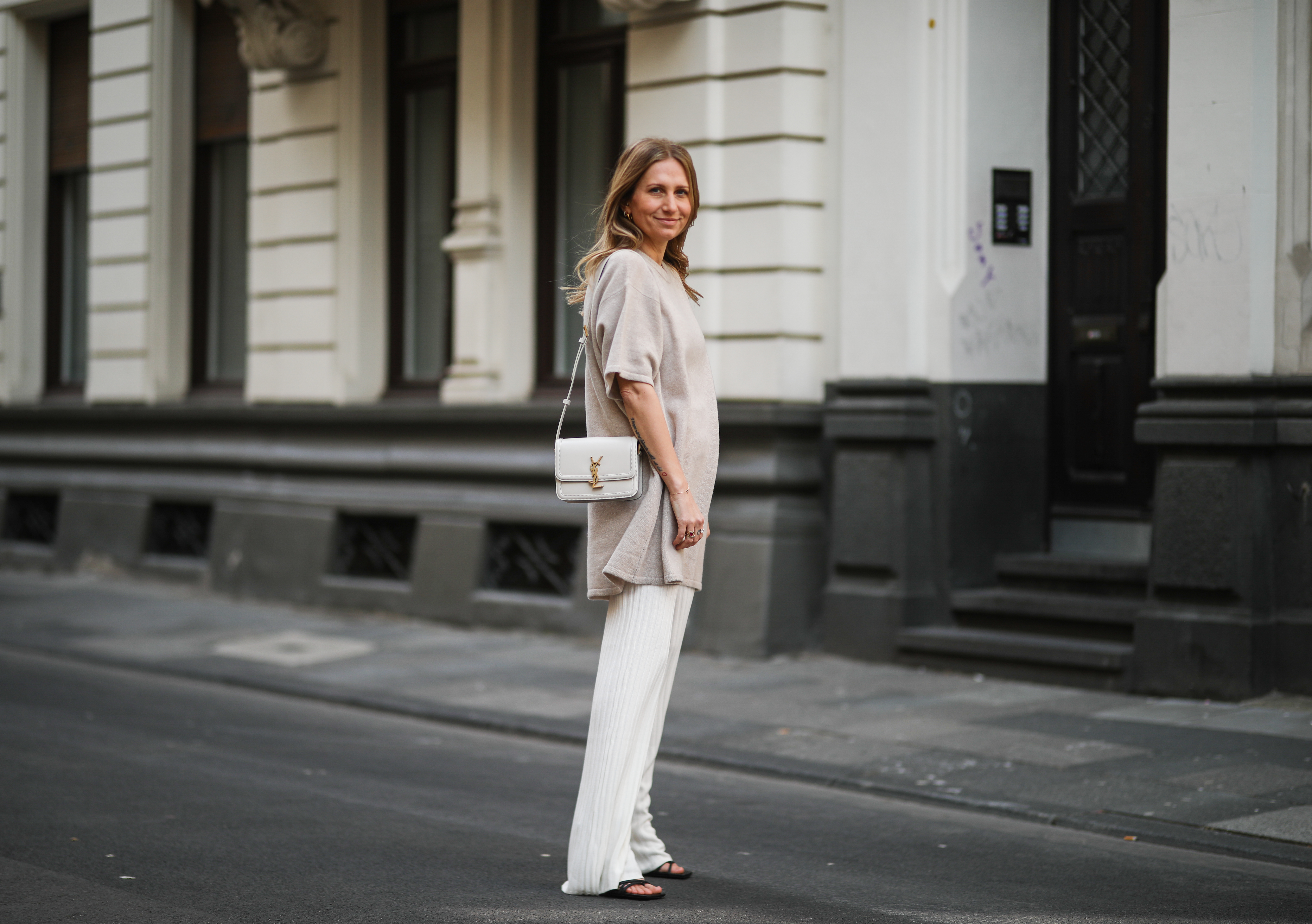 woman wearing beige sweater and white pants
