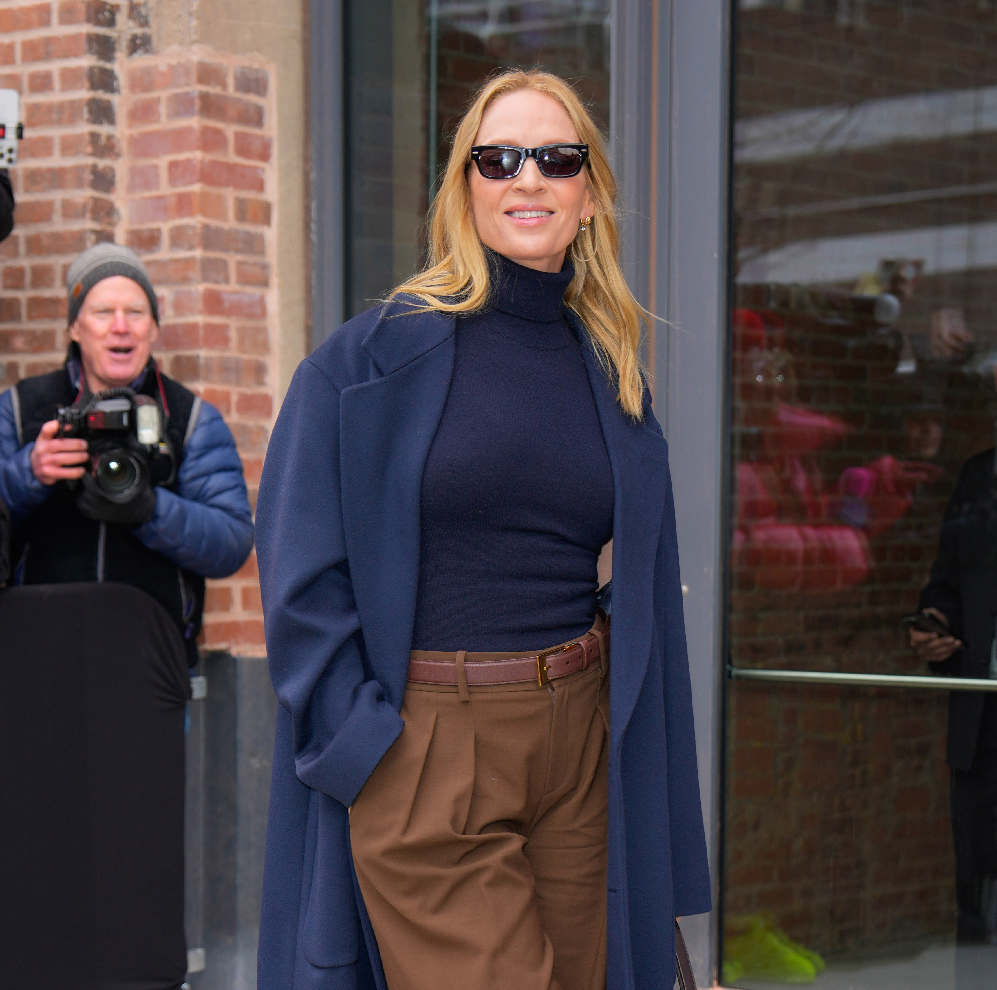 uma thurman in navy top and brown pants