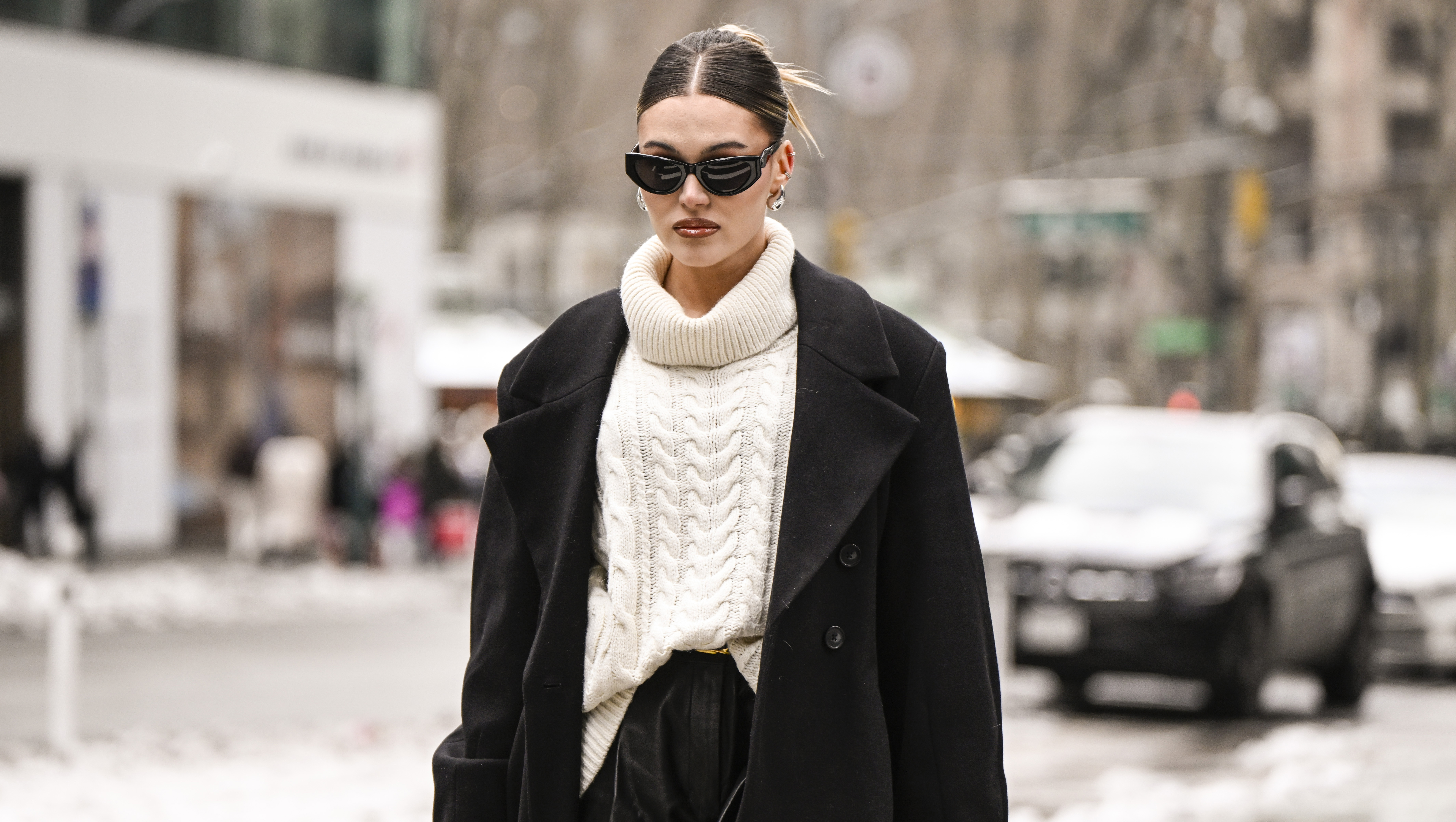 NEW YORK, NEW YORK - FEBRUARY 09: Natalie Zarra is seen wearing a black coat, cream sweater, black leather shorts, black sunglasses and Chanel bag outside the Lapointe show during NYFW F/W 2025 on February 09, 2025 in New York City. (Photo by Daniel Zuchnik/Getty Images)