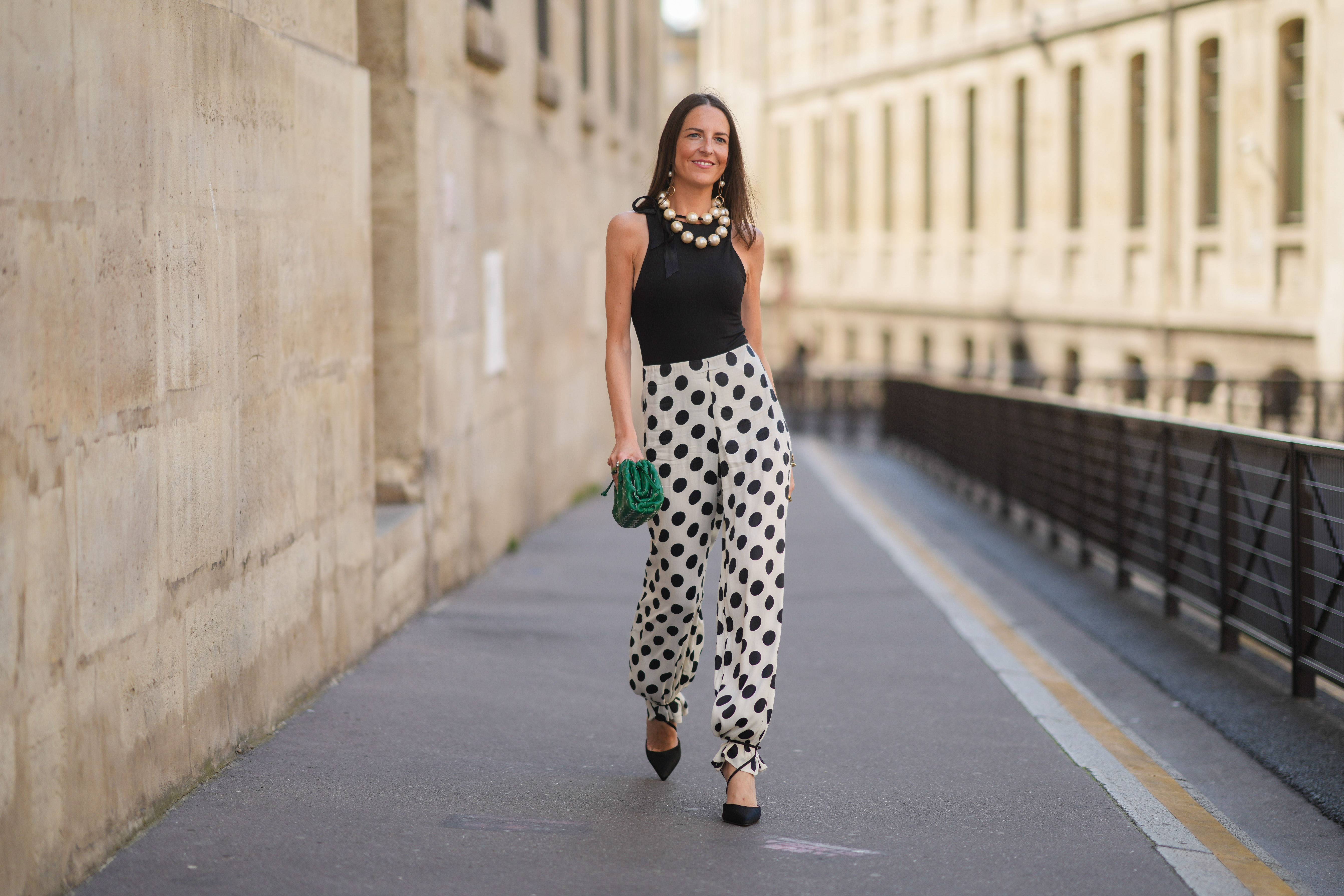 woman in black and white polka dotted pants, top and heels