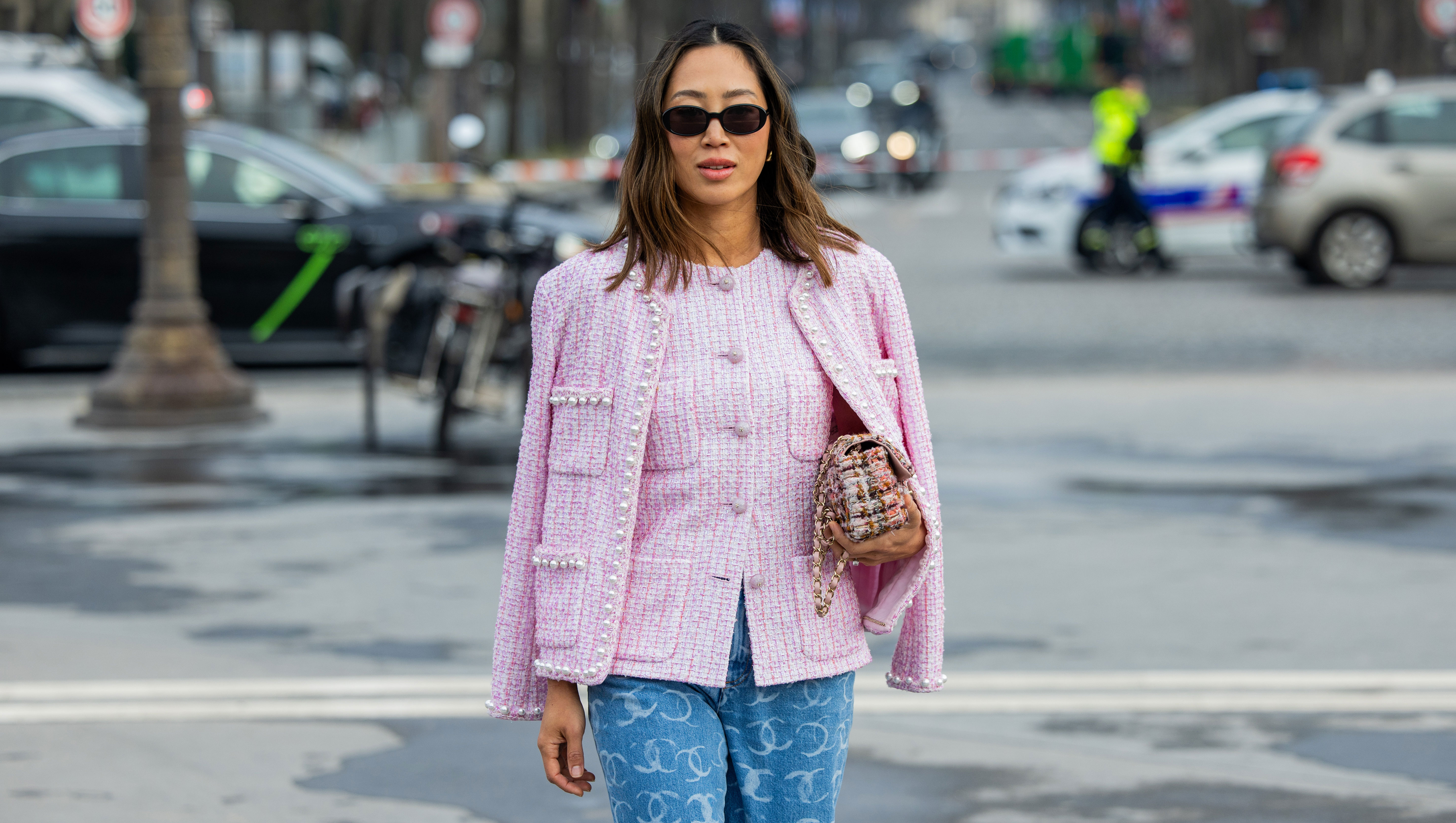 PARIS, FRANCE - MARCH 11: Aimee Song wears pink button up blouse, jacket, denim jeans with logo print, bag, sunglasses outside Chanel during the Womenswear Fall/Winter 2025/2026 as part of Paris Fashion Week on March 11, 2025 in Paris, France. (Photo by Christian Vierig/Getty Images)