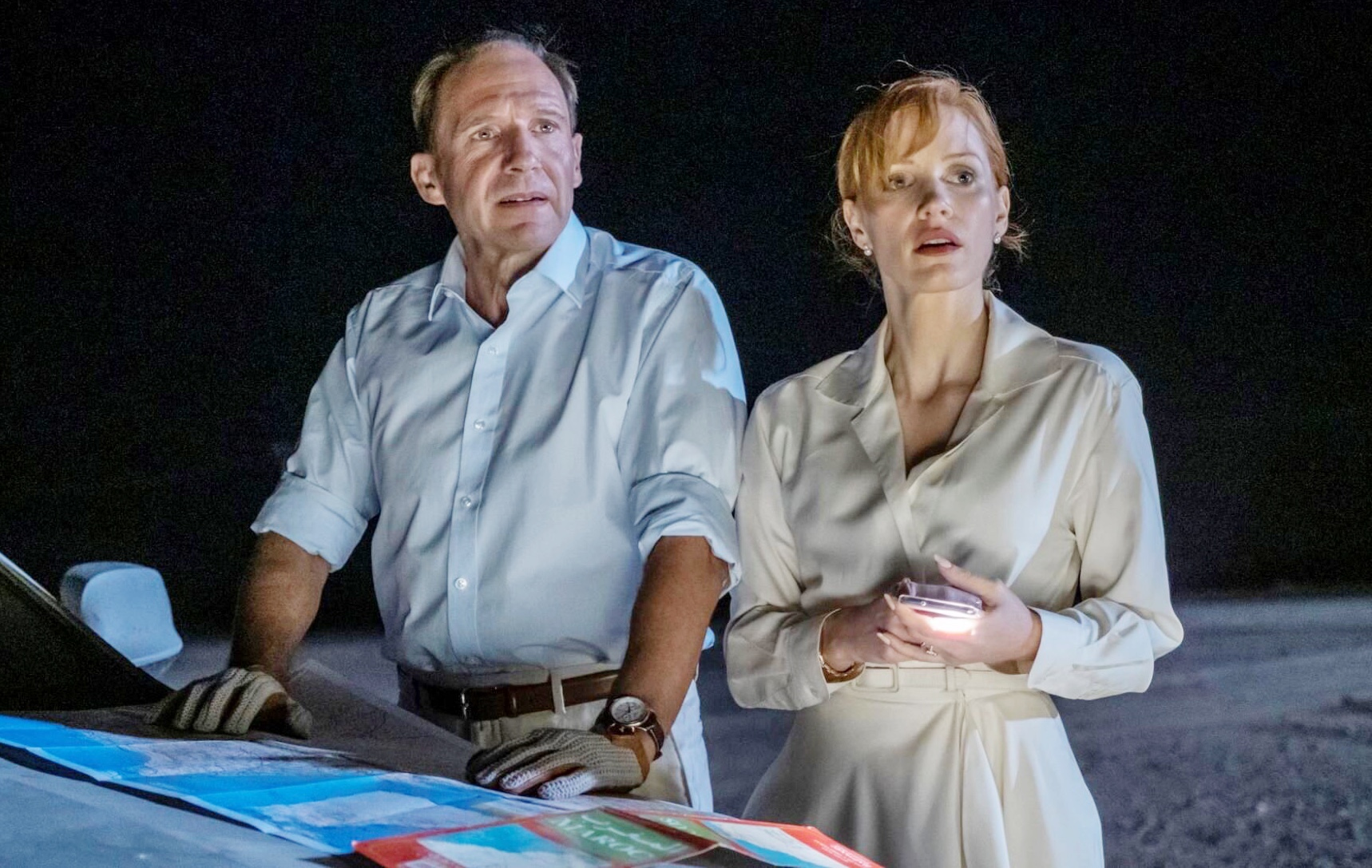 A man and a woman stand by a car at night in The Forgiven.