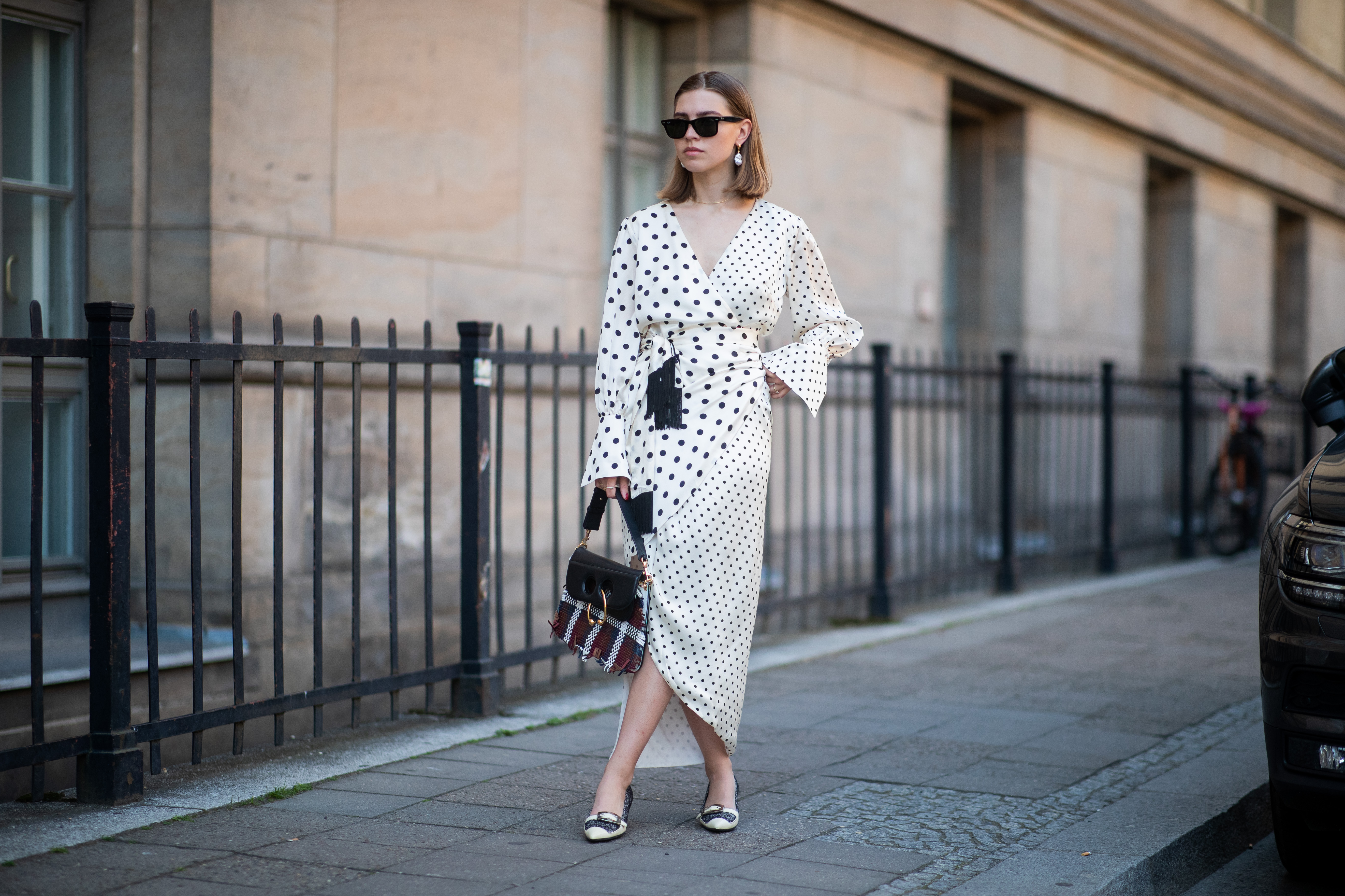 Swantje Sömmer is seen wearing white dress with black dots print Mother of Pearl, JW Anderson plaid bag, Prada shoes in black and white, Ray Ban sunglasses on June 05, 2019 in Berlin, Germany.