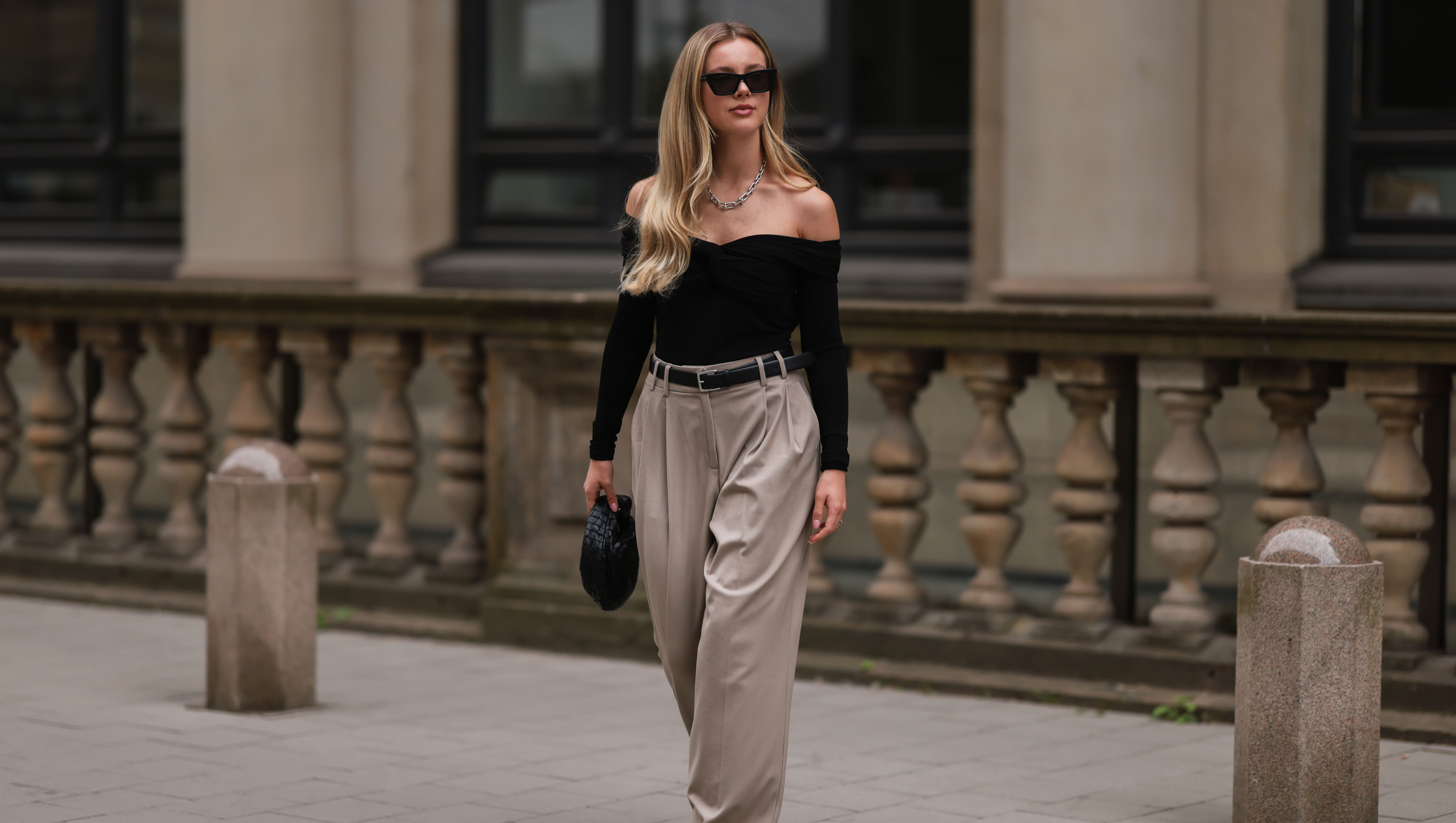 HAMBURG, GERMANY - AUGUST 29: Isabelle Hartmann is seen wearing Bottega Veneta mini Jodie black leather bag, Saint Laurent black silver heels, Edited x Isabelle Hartmann wide leg beige pants, Filippa K black silver leather belt, Khaite black off shoulder top, Tiffany & Co City Hardwear silver chain and Saint Laurent black shades on August 29, 2022 in Hamburg, Germany. (Photo by Jeremy Moeller/Getty Images)