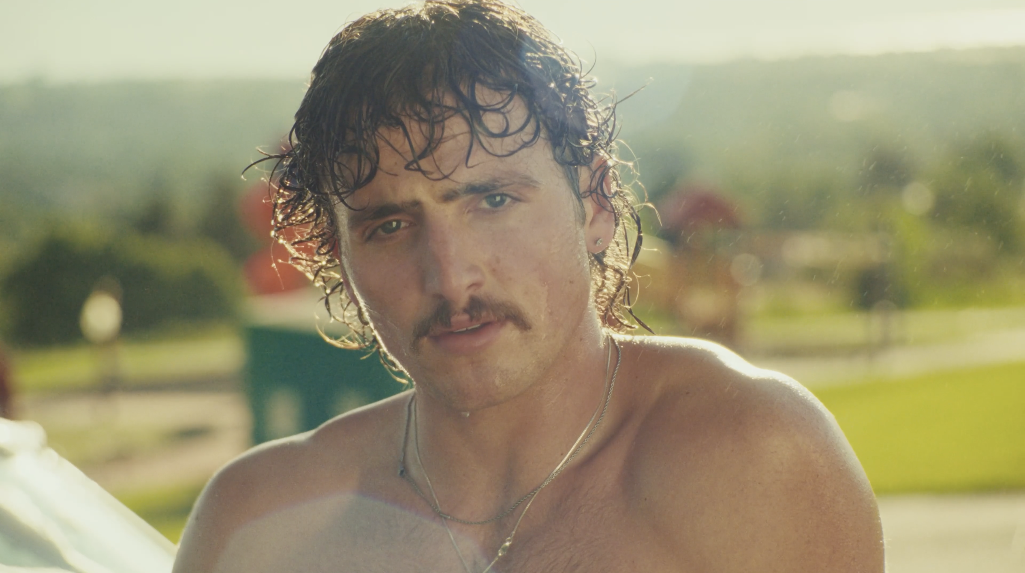 Benson Boone shirtless in his "Mr. Electric Blue" music video