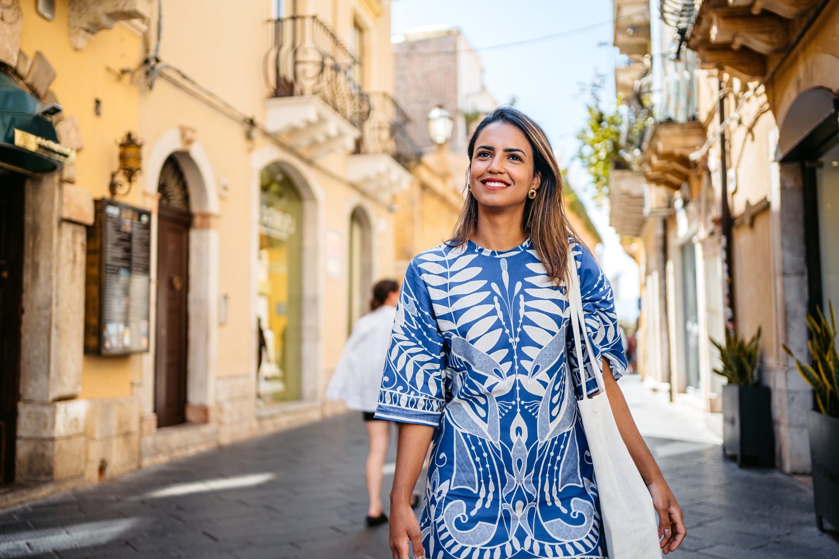 Beautiful young Brazilian woman walking on town square in Taormina in Sicily.
