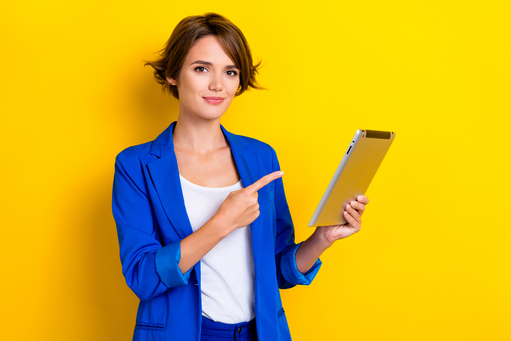 Photo of confident cheerful woman wear blue jacket pointing finger apple samsung modern gadget isolated yellow color background.