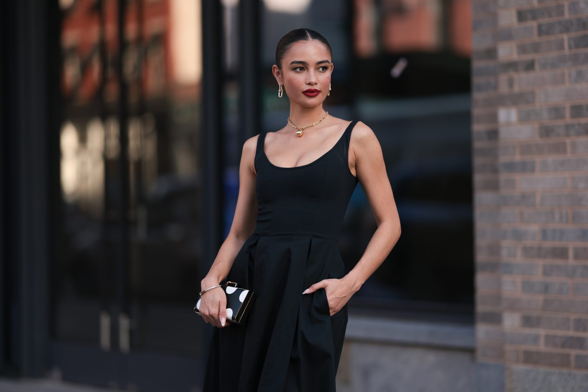 NEW YORK, NEW YORK - SEPTEMBER 12: Sara Sampaio is seen wearing yellow-gold earrings a necklace from Tiffany & Co., HardWear Collection; a sleeveless, round-necked, black midi dress; a silver bracelet; a black clutch with white polka dots before the Carolina Herrera Spring Summer 2024 Runway Show on September 12, 2023 in New York City. (Photo by Jeremy Moeller/Getty Images)