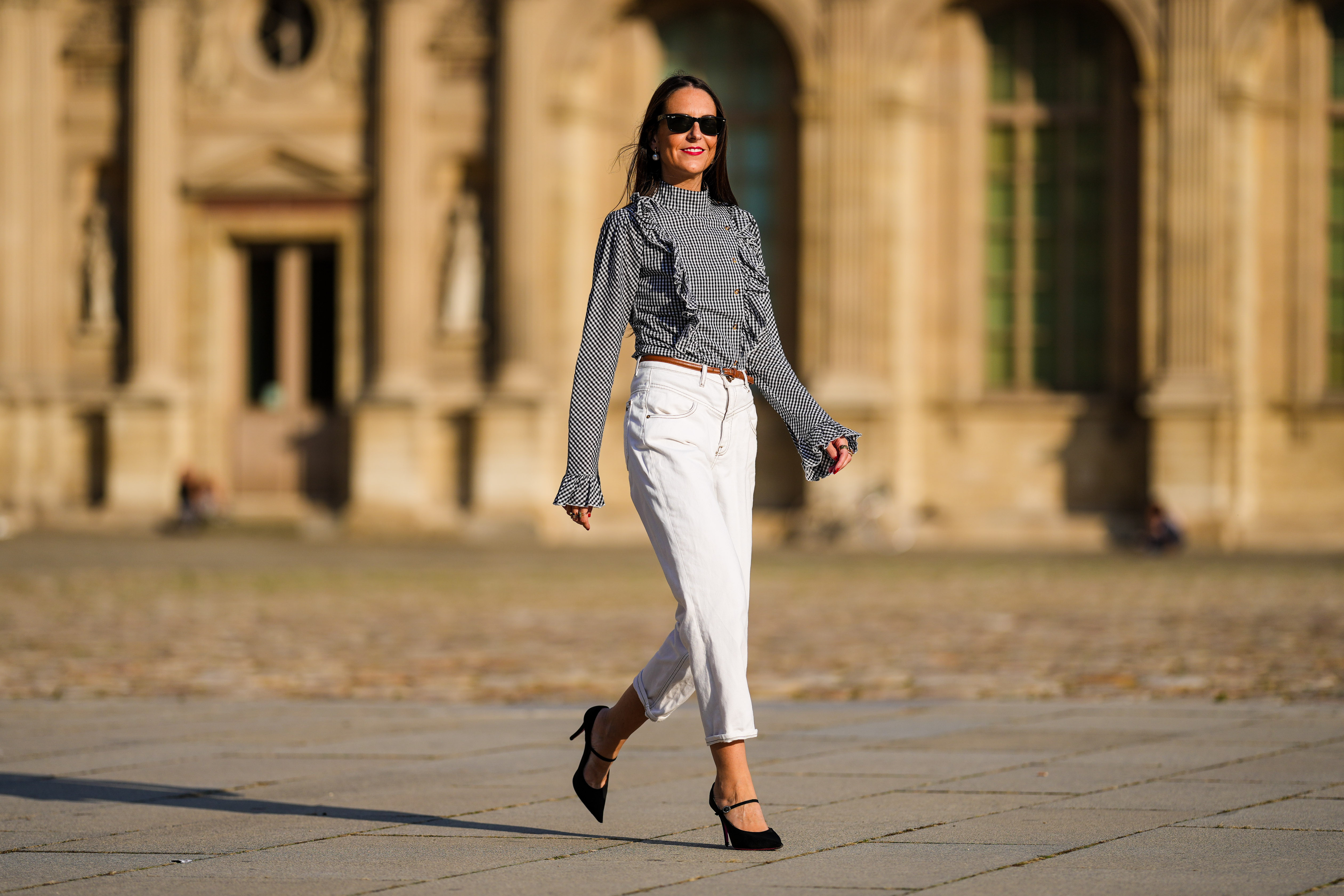 Alba Garavito Torre wears a gingham checkered black and white shirt with Long Sleeve Ruffles from Serendipia, Mom jeans in white from Maison 123 Paris, a brown leather thin belt, Black Mary Jane high heels shoes from Gucci, on October 10, 2021 in Paris, France.