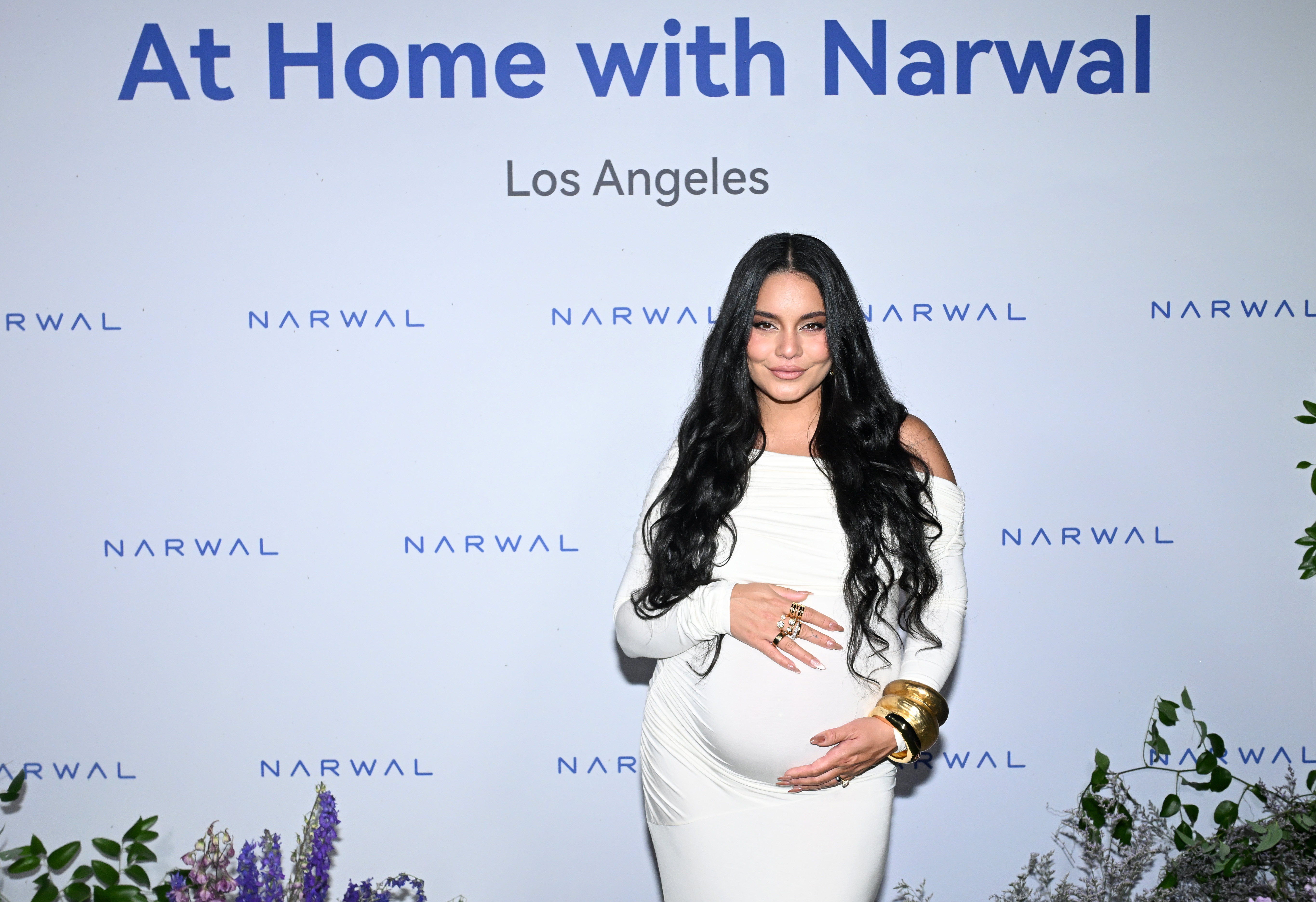 Pregnant Vanessa Hudgens cradling her baby bump at Narwal's summer soiree.